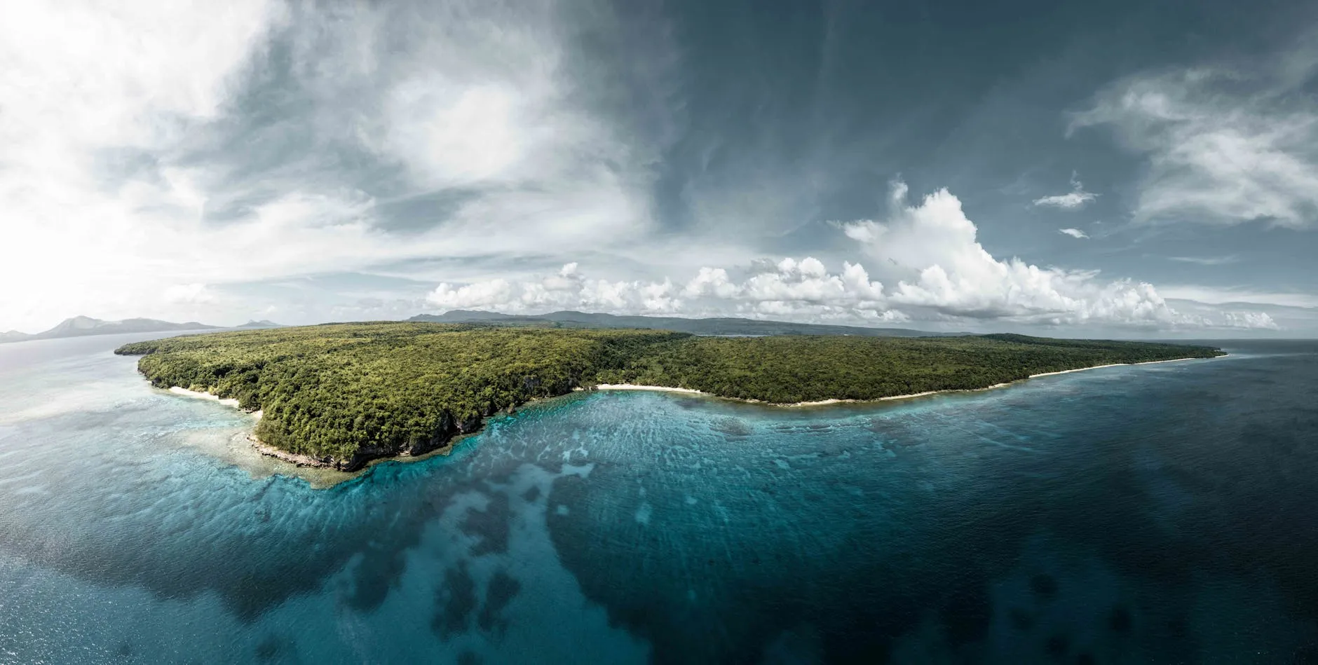 Port Vila, Vanuatu — A breathtaking aerial view of the lush green coastline of Vanuatu, surrounded by crystal clear waters.