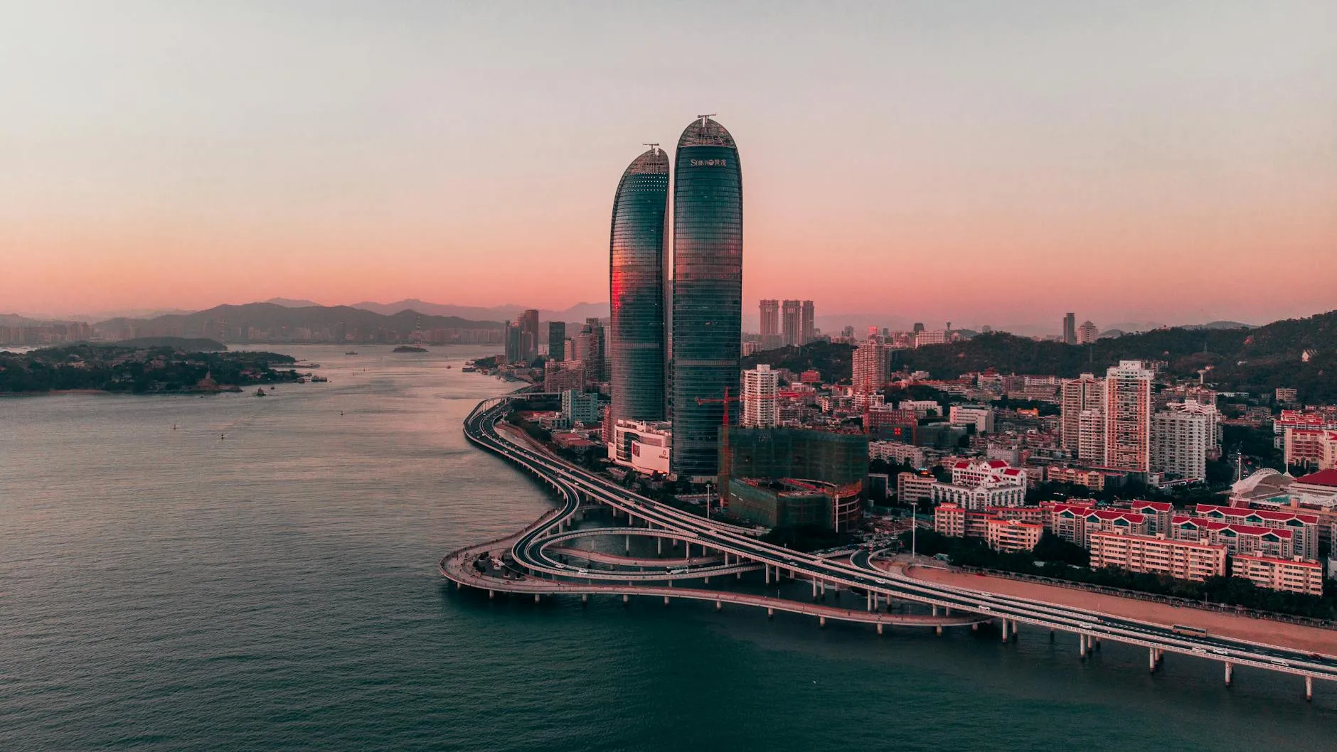 Xiamen China — Stunning aerial view of Xiamen skyline featuring skyscrapers and coastline at sunset.