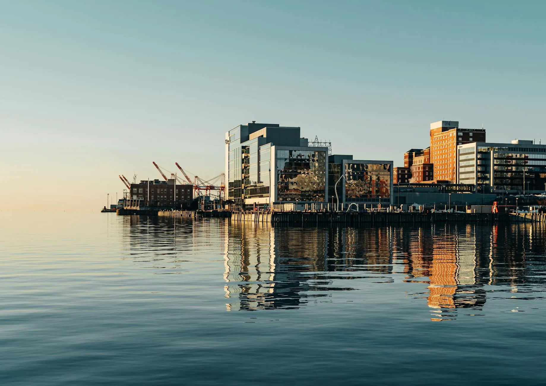 Halifax Stanfield Airport (YHZ) — Ocean near dock and modern buildings in city district under cloudless blue sky in daylight