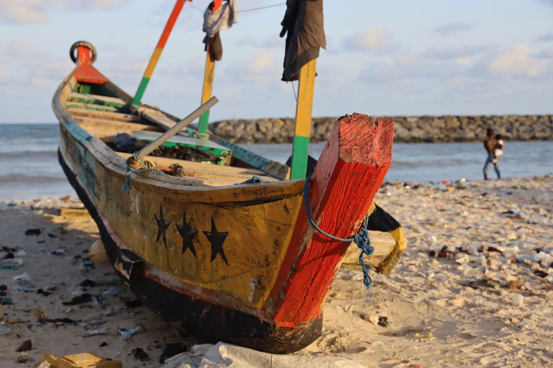Ghana — Colorful fishing boat on a sandy beach in Accra, Ghana, with the ocean backdrop.