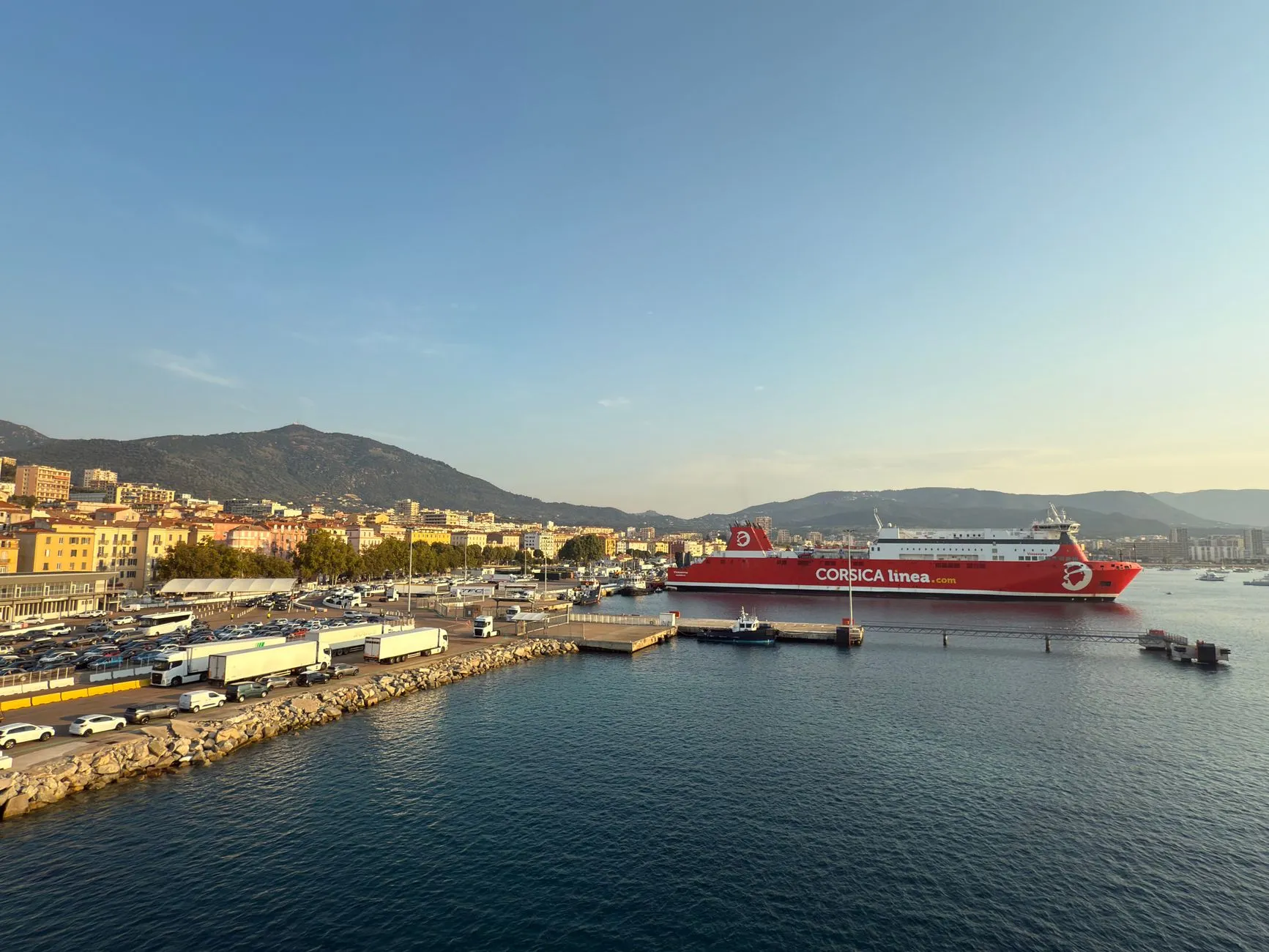Ajaccio, Corsica — Scenic view of a ferry at Ajaccio port in Corsica, France with a mountainous backdrop and clear skies.
