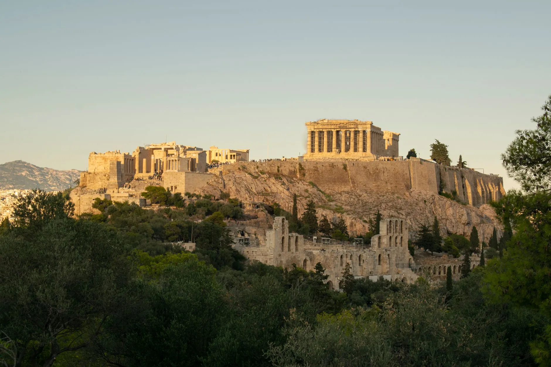 Greece — Capture of the historic Acropolis in Athens, Greece during sunset, showcasing ancient architecture and surrounding landscape.