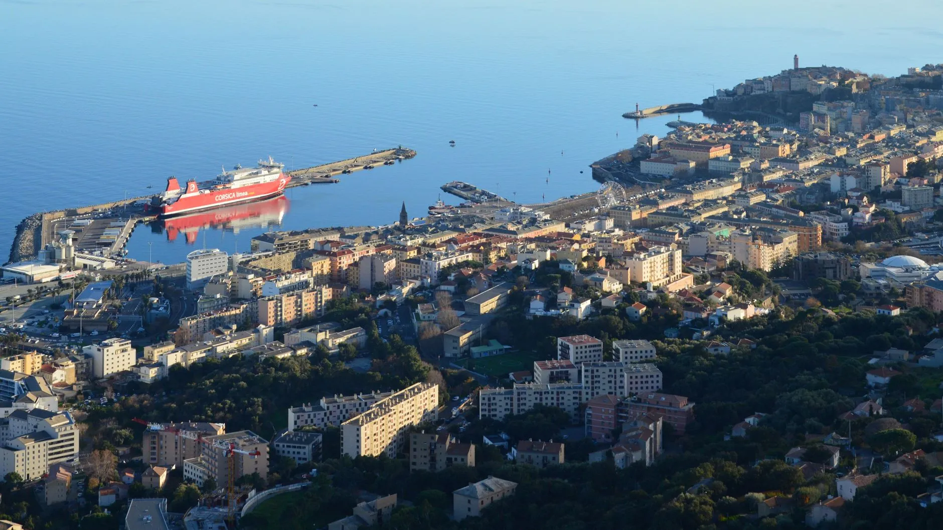 Bastia, Corsica — High-angle shot of Bastia Harbor and cityscape in Corsica, featuring a ferry docked at the port.