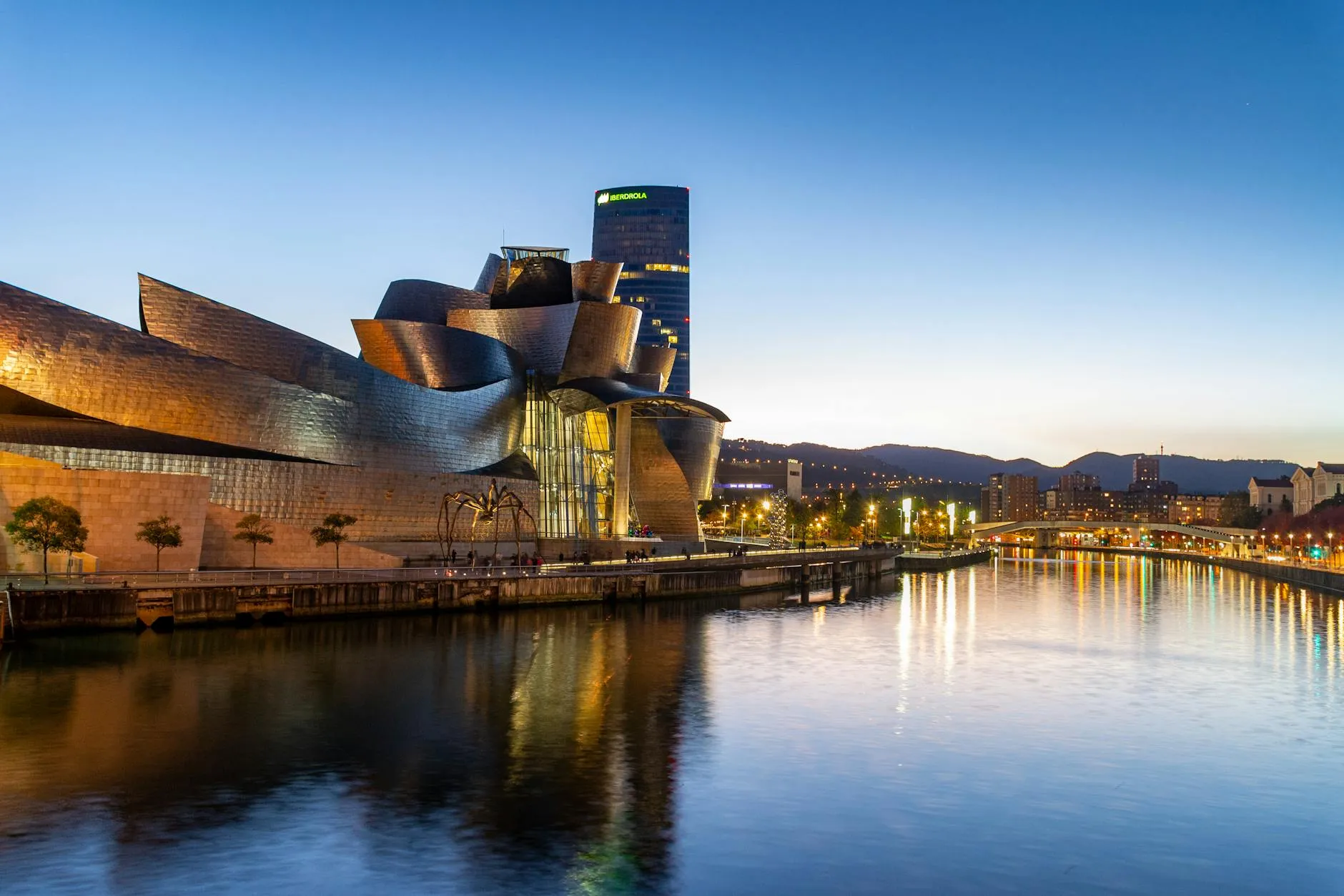 Bilbao, Spain — Stunning view of the Guggenheim Museum Bilbao reflecting in the Nervion River at dusk.