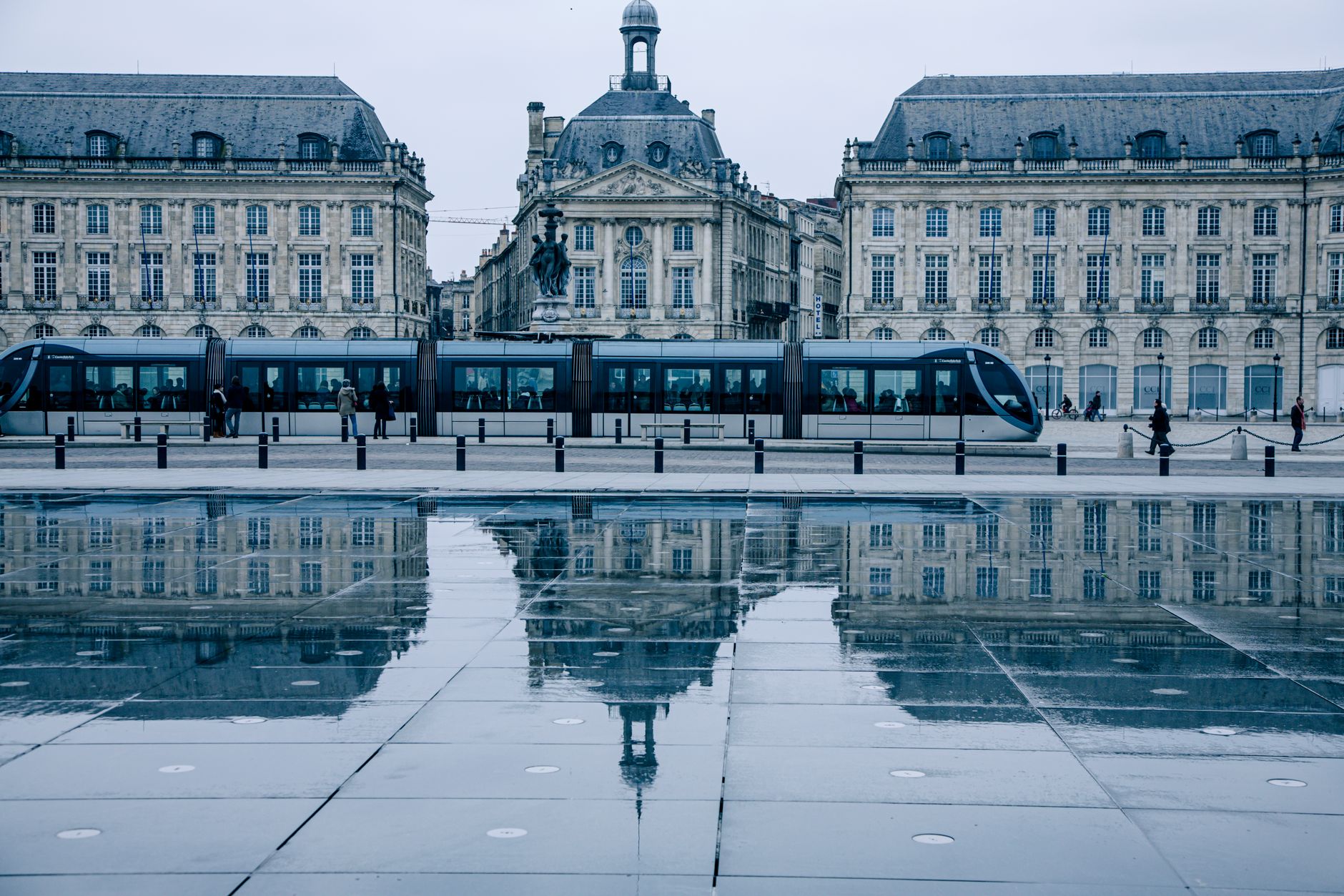Bordeaux, France — Tram passing by the historic Place de la Bourse in Bordeaux, reflecting on the Miroir d'eau.
