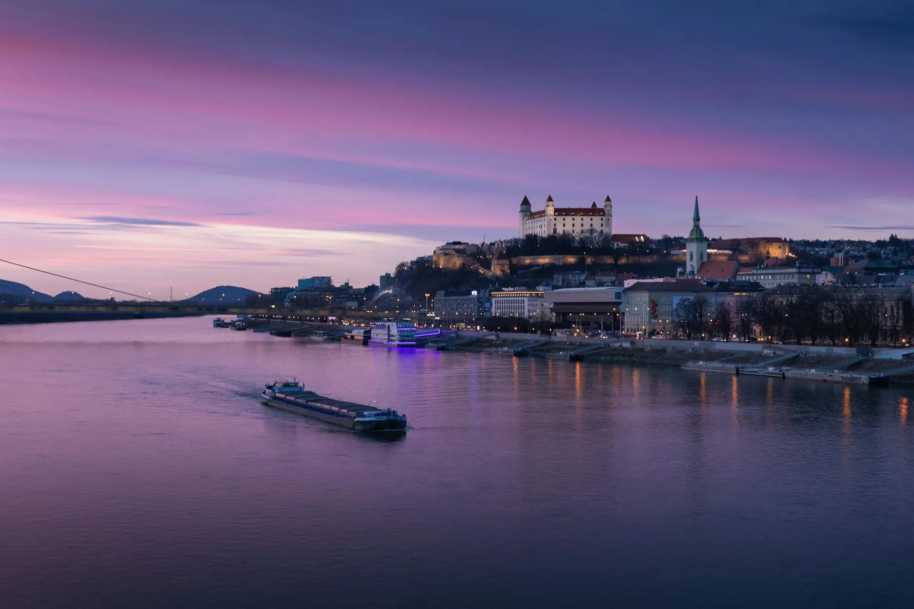 Bratislava, Slovakia — A picturesque view of Bratislava Castle and Danube River at sunset, showcasing Slovakia's scenic cityscape.