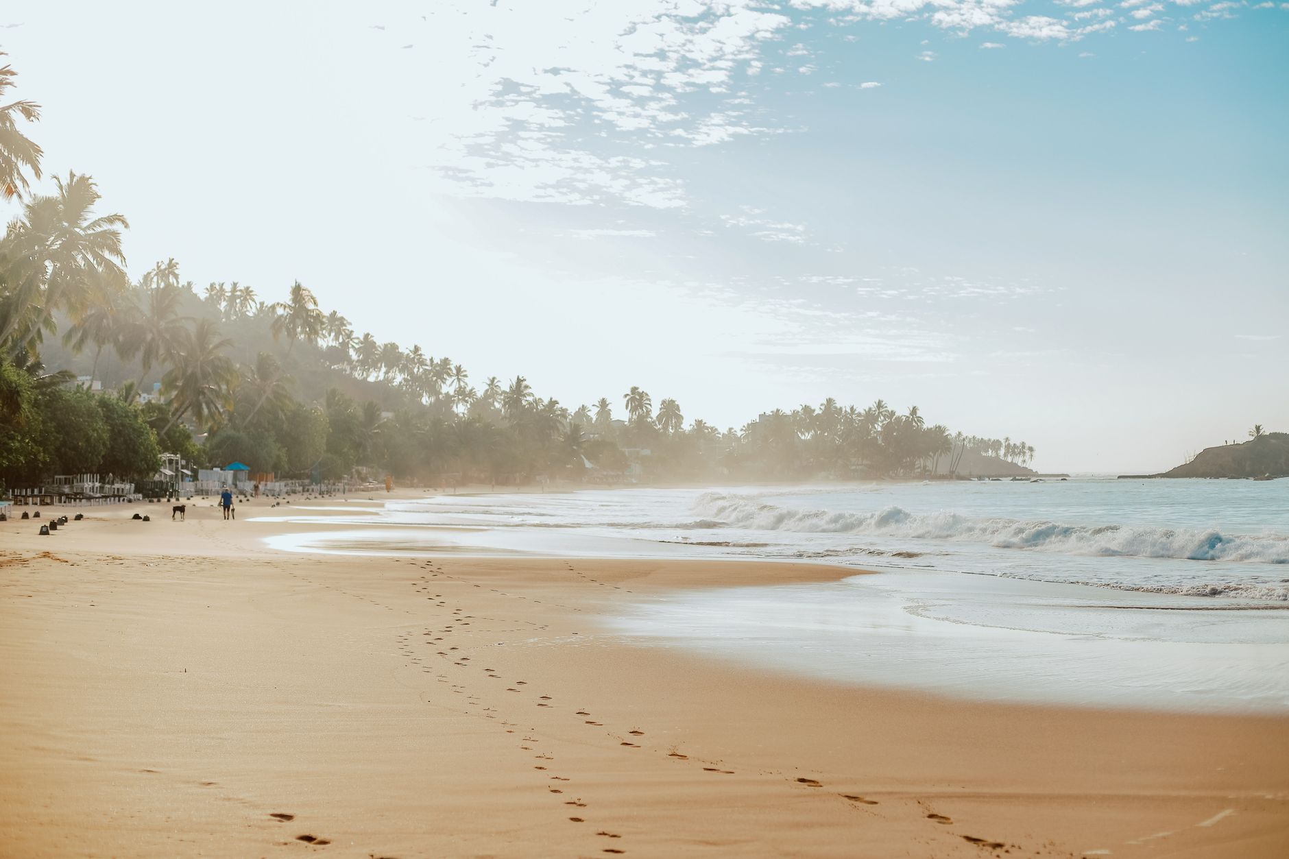 Sri Lanka — Footprints in the sand on a tranquil beach in Mirissa, Sri Lanka at sunrise.