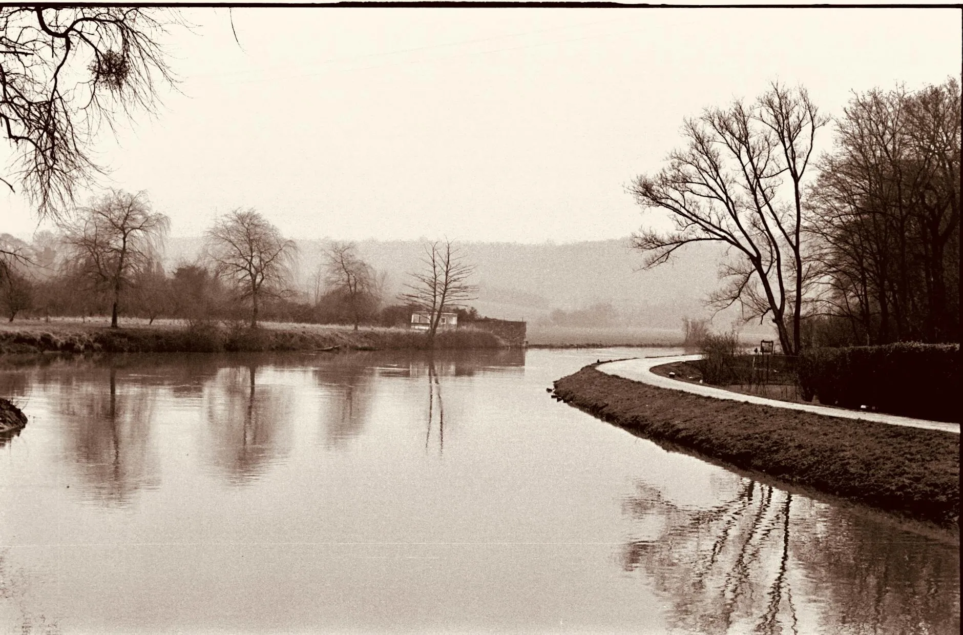 Charleroi, Belgium — Calm river scene in Charleroi, Belgium capturing reflections and bare winter trees.
