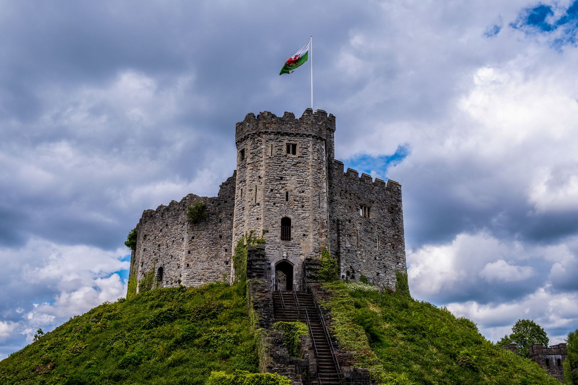 Cardiff, Wales — Majestic Cardiff Castle in Wales, topped by a flag, under dramatic cloudy skies.