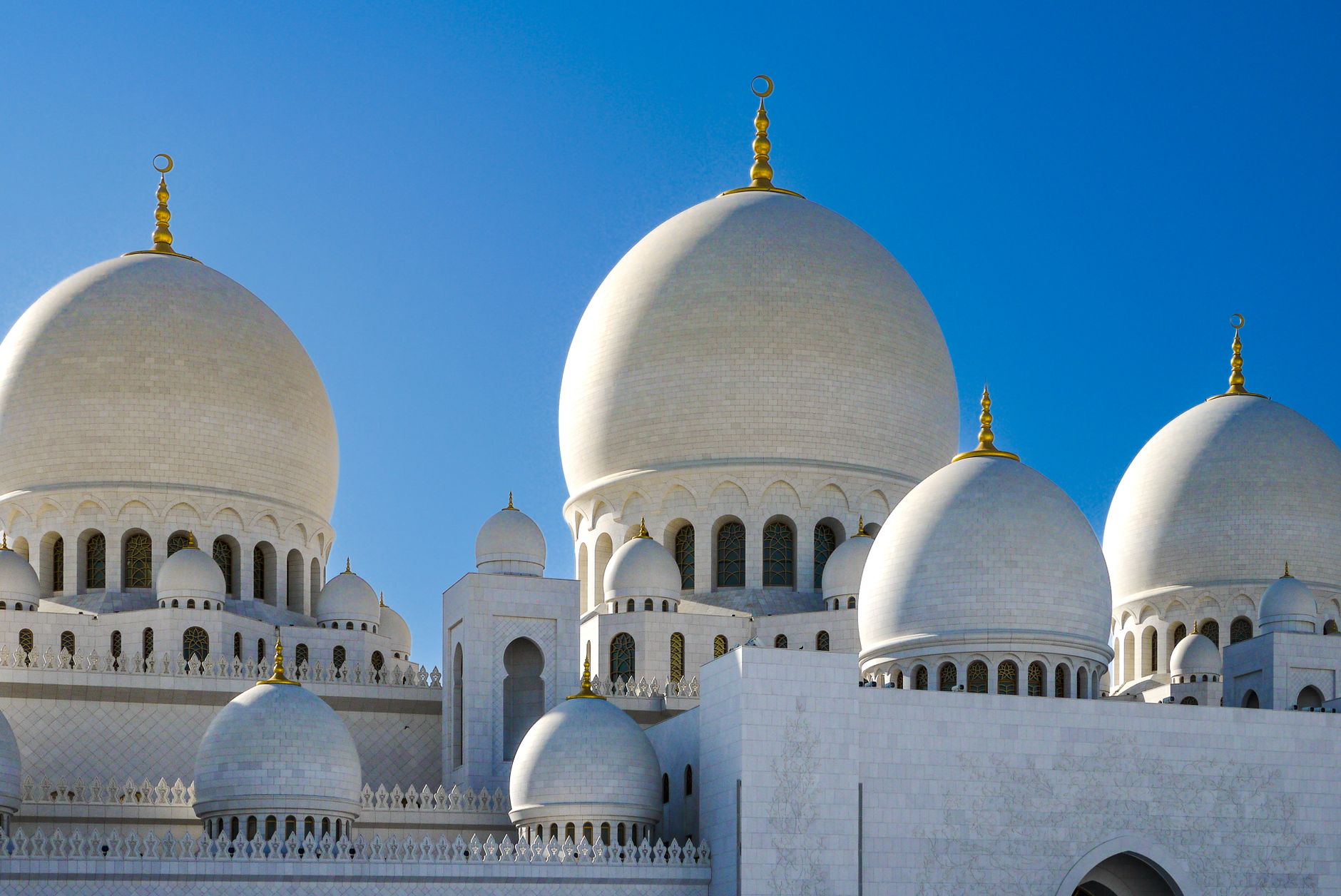 The UAE — Elegant view of Sheikh Zayed Grand Mosque's domes against clear blue skies in Abu Dhabi, UAE.