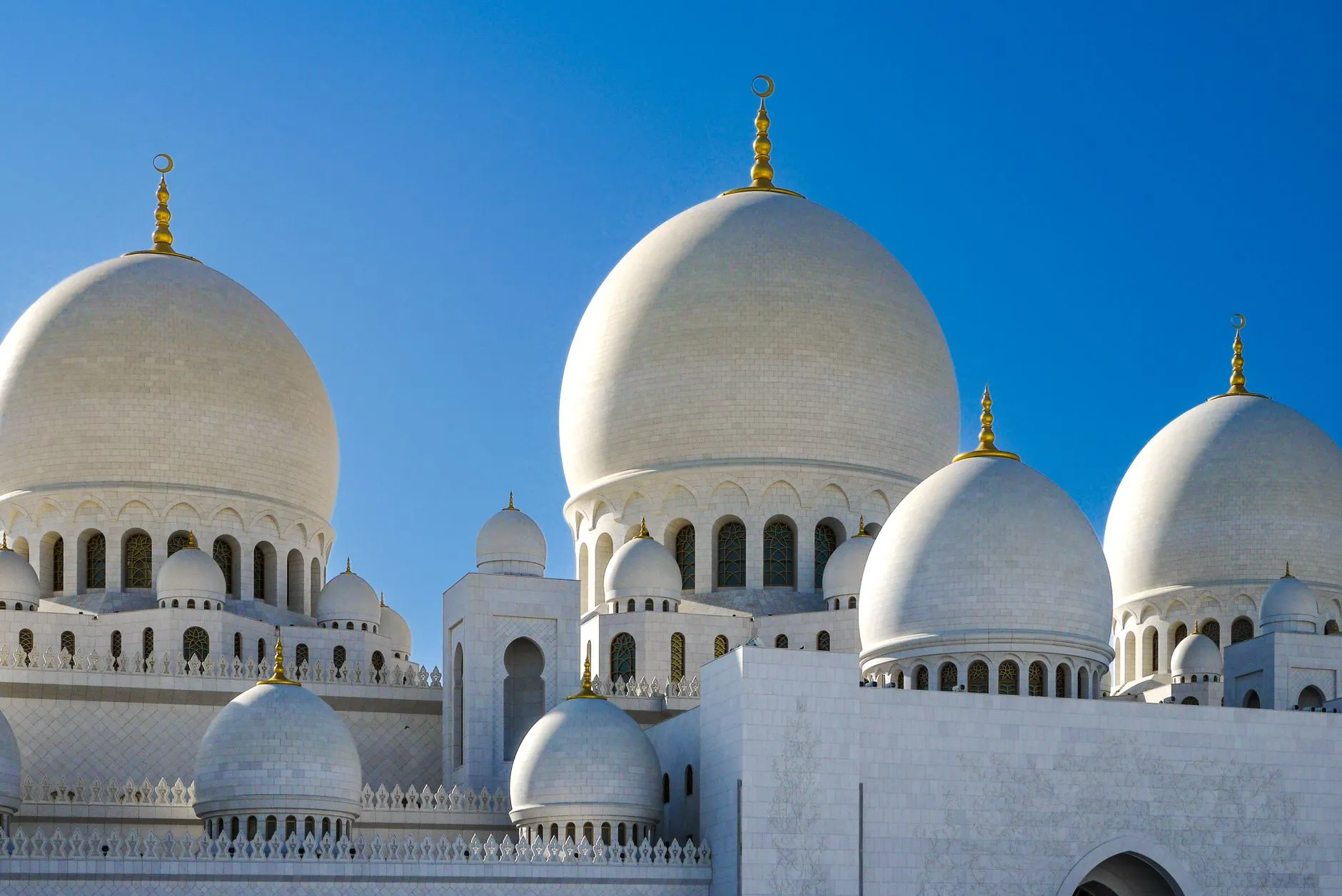 The UAE — Elegant view of Sheikh Zayed Grand Mosque's domes against clear blue skies in Abu Dhabi, UAE.