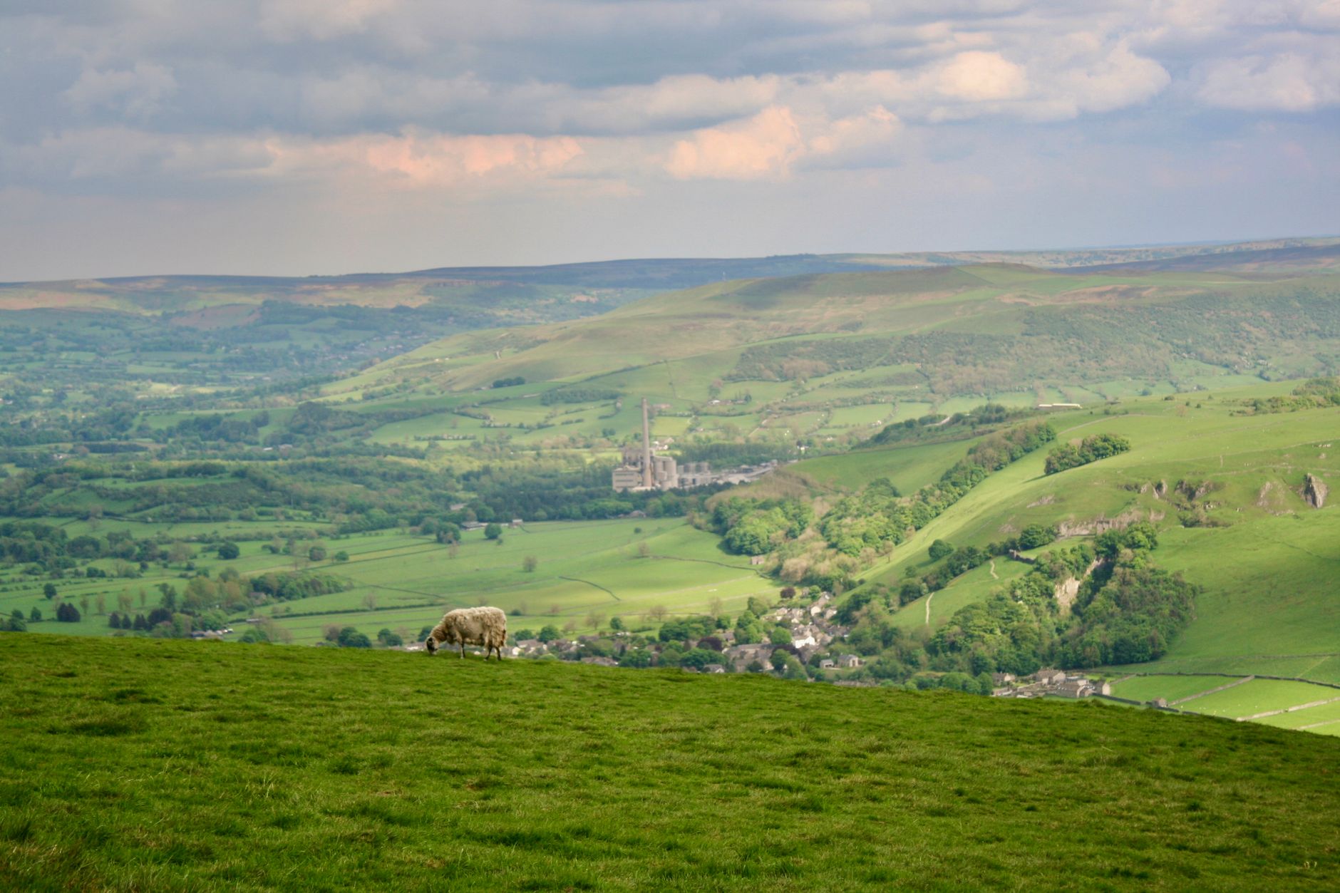East Midlands, England — Breathtaking vista of Castleton in Peak District, England, with lush hills and a grazing sheep.