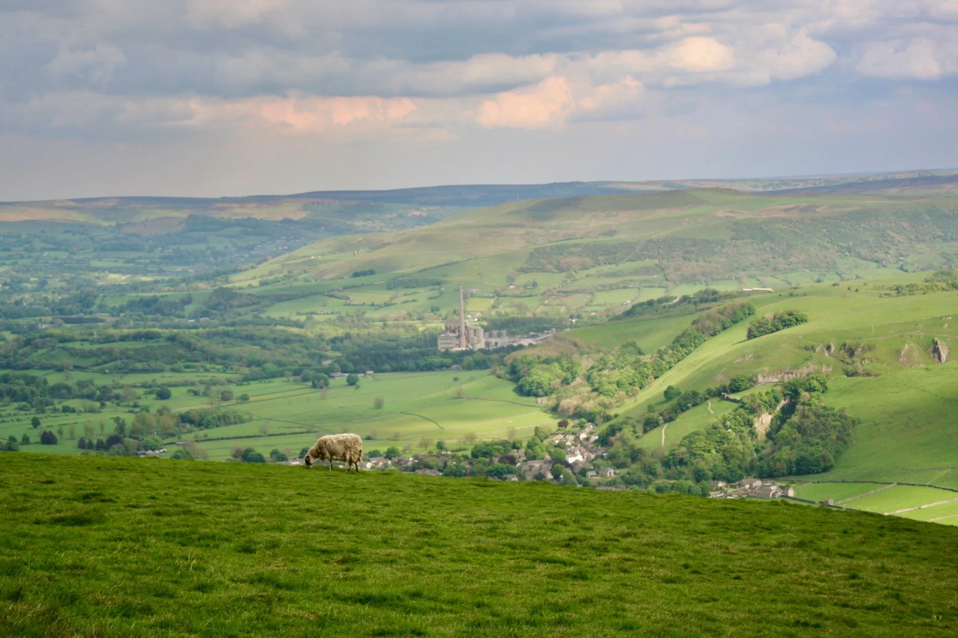 East Midlands, England — Breathtaking vista of Castleton in Peak District, England, with lush hills and a grazing sheep.