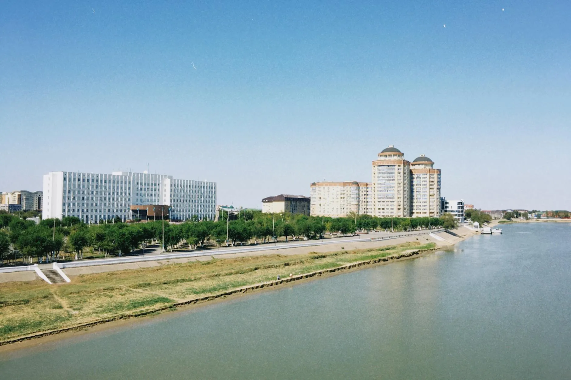Atyrau, Kazakhstan — A scenic daytime view of Atyrau city skyline with modern buildings along the Ural River in Kazakhstan.