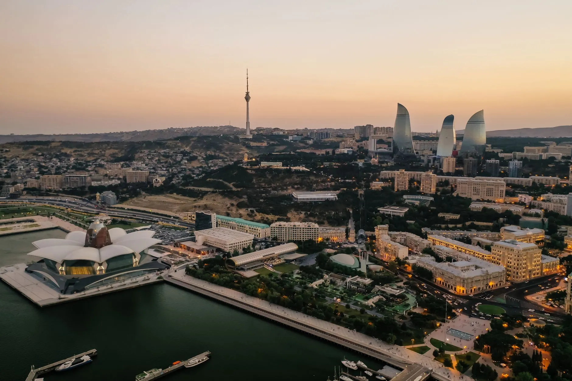 Azerbaijan — Aerial view of Baku's skyline featuring the Flame Towers and Caspian Sea at dusk.