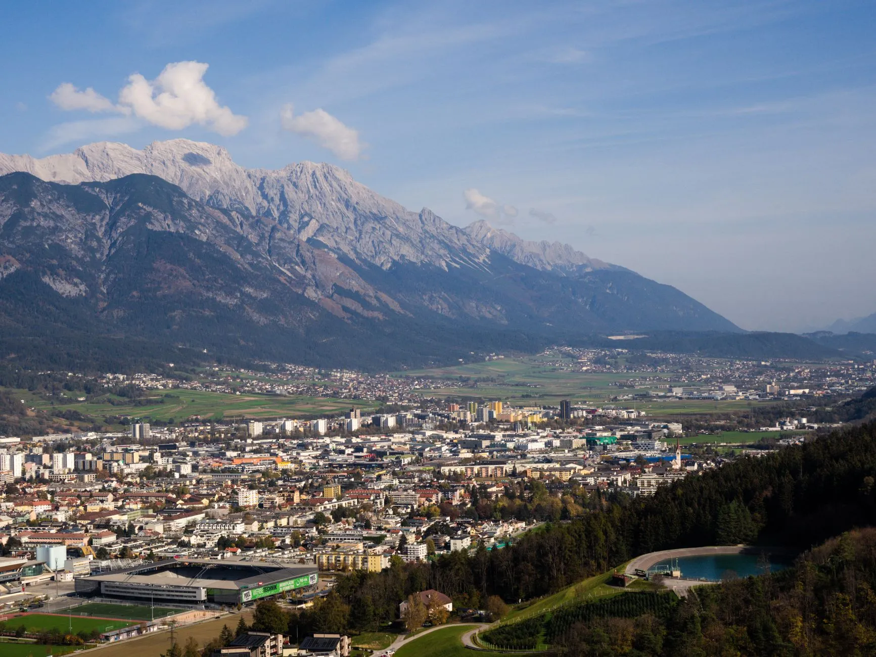 Innsbruck, Austria — Aerial view of Innsbruck, Austria with the stunning Alps in the background, captured on a clear day.