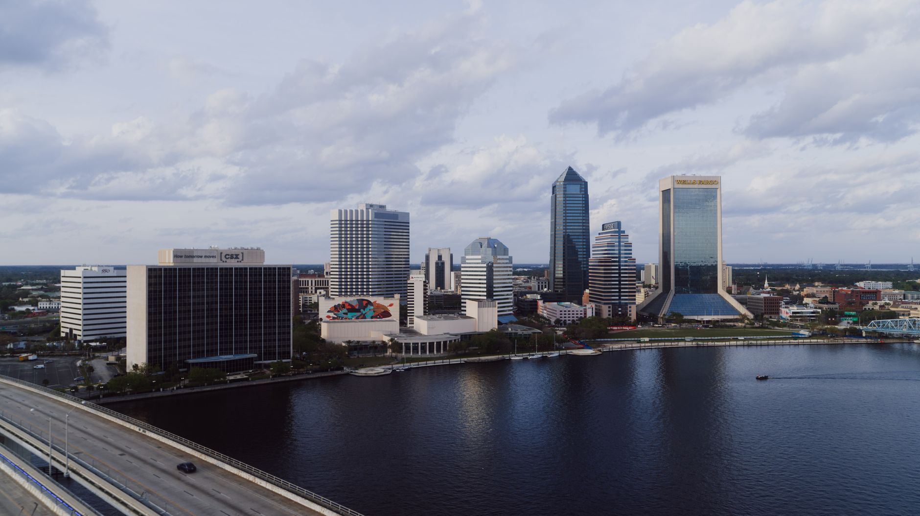 Jacksonville, USA — A stunning aerial view of Jacksonville's modern skyline by the river under a cloudy sky.