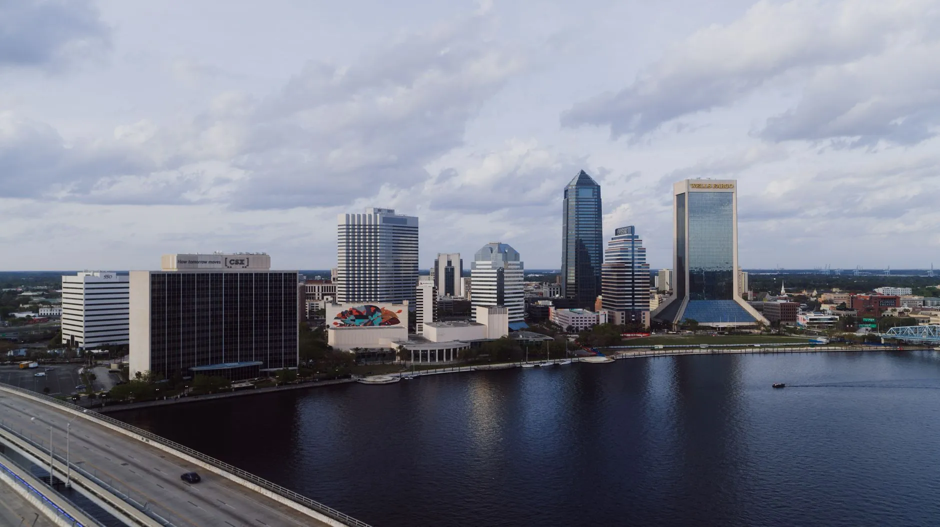 Jacksonville, USA — A stunning aerial view of Jacksonville's modern skyline by the river under a cloudy sky.