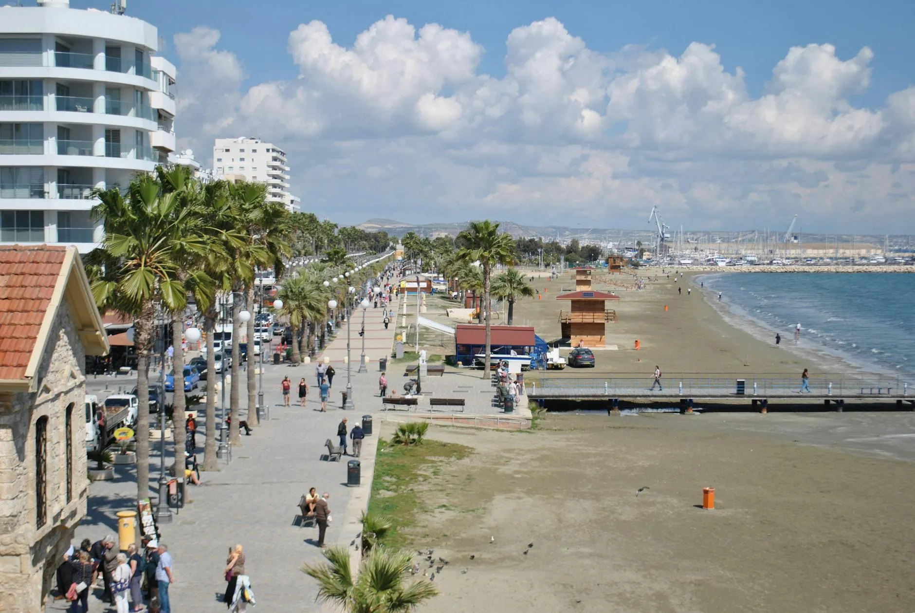 Larnaca, Cyprus — Scenic view of Larnaca promenade and beachfront with people walking and palm trees.