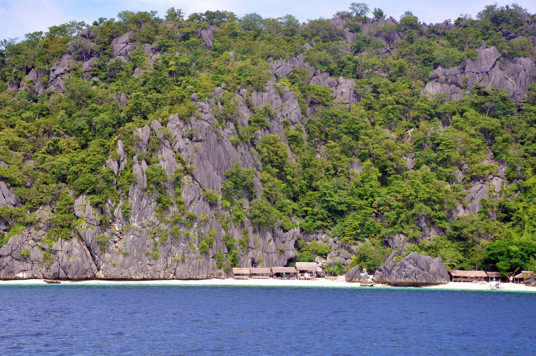 Limestone karst cliffs and a white-sand beach in Coron, Palawan, Philippines