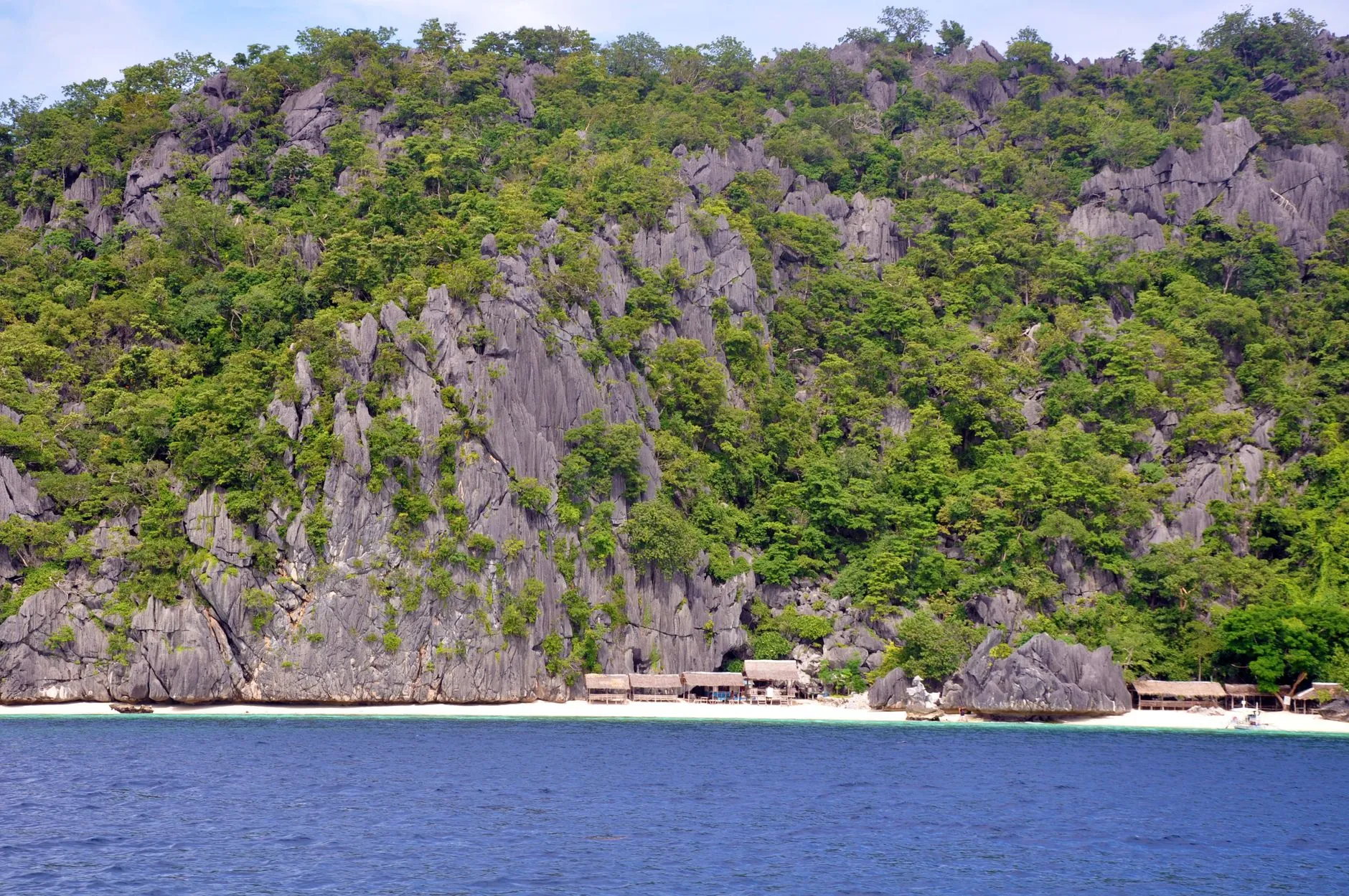 Limestone karst cliffs and a white-sand beach in Coron, Palawan, Philippines