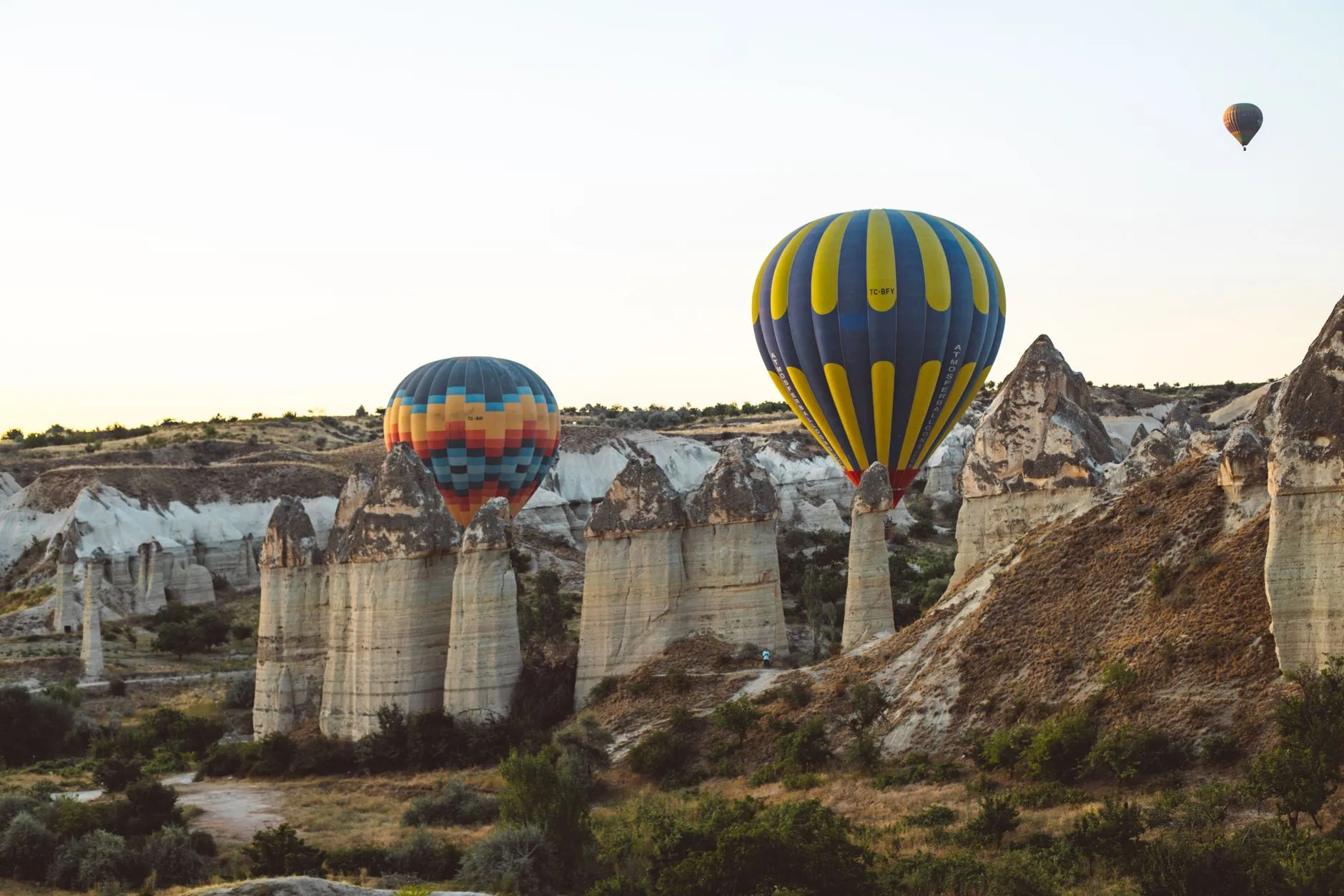 Cappadocia, Türkiye — Scenic view of hot air balloons floating over Cappadocia's iconic fairy chimneys at sunrise.