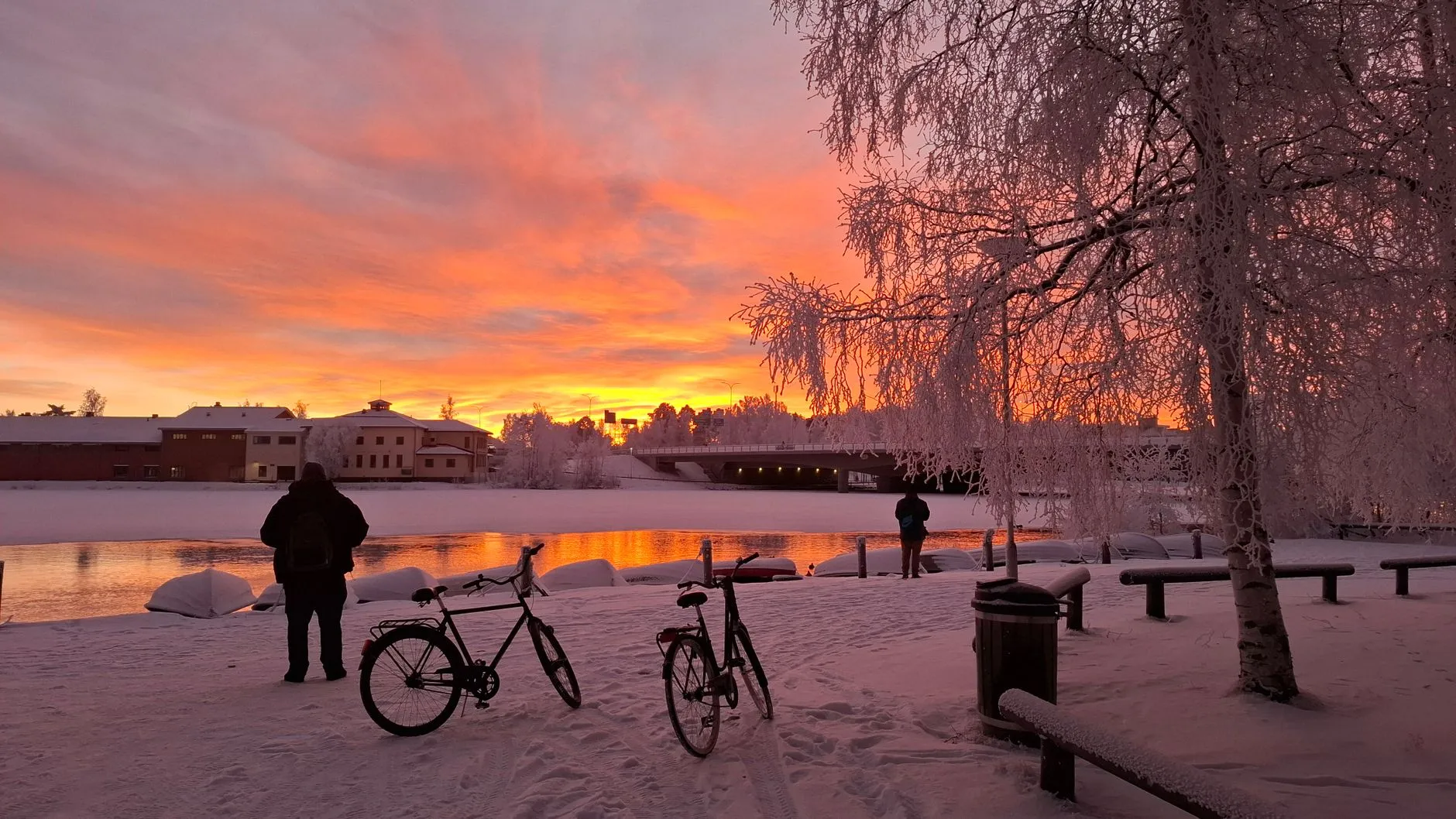 Oulu, Finland — Serene winter sunset with snow-covered landscape and frozen river in Oulu, Finland.