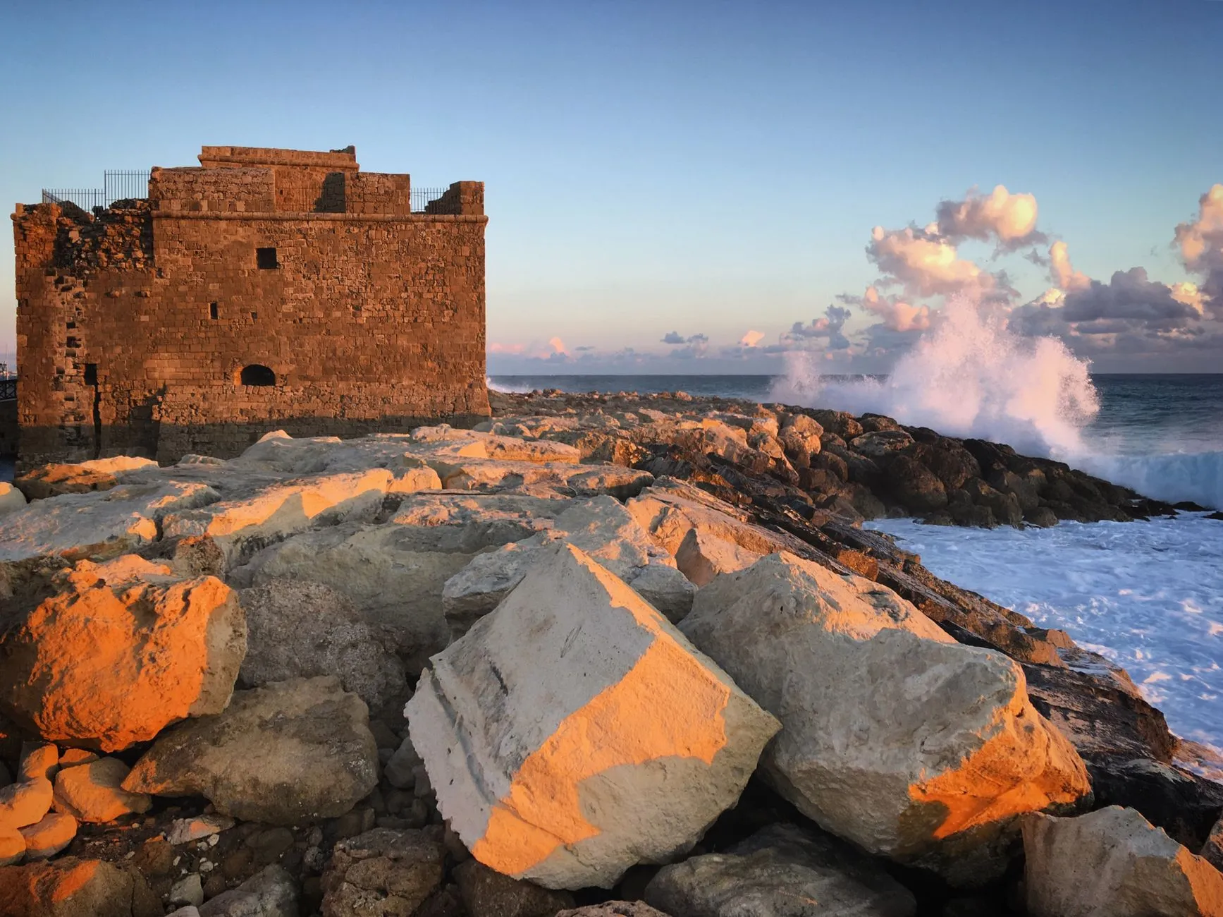 Paphos, Cyprus — Stunning sunset view of a medieval castle on the rocky coastline of Paphos, Cyprus, highlighting historical architecture.