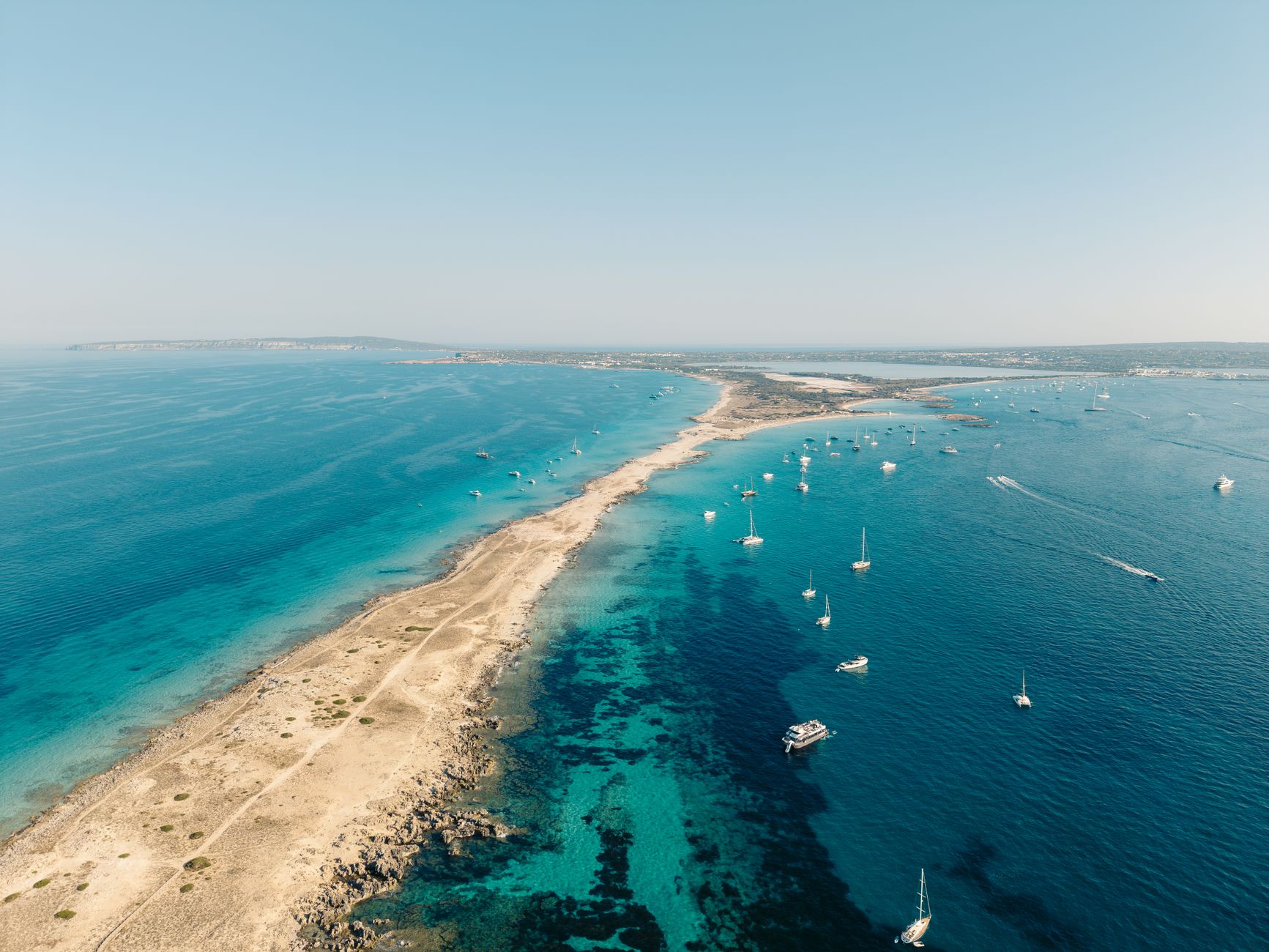 The Balearic Islands — Stunning aerial view of Formentera's coastline with turquoise waters and sailing boats in Balearic Islands, Spain.