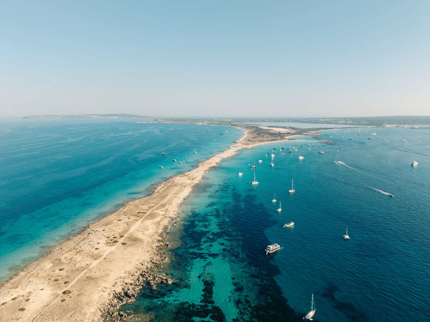 The Balearic Islands — Stunning aerial view of Formentera's coastline with turquoise waters and sailing boats in Balearic Islands, Spain.