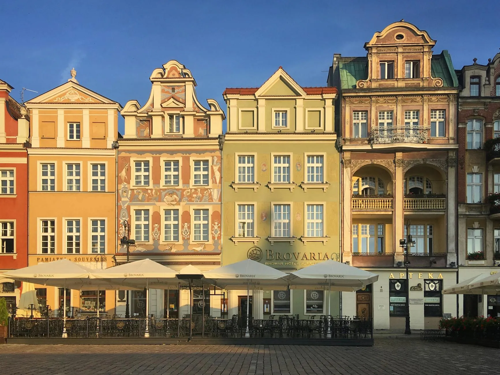 Poznań, Poland — Vibrant tenement buildings in Poznań's historic Old Market Square bathed in sunlight.