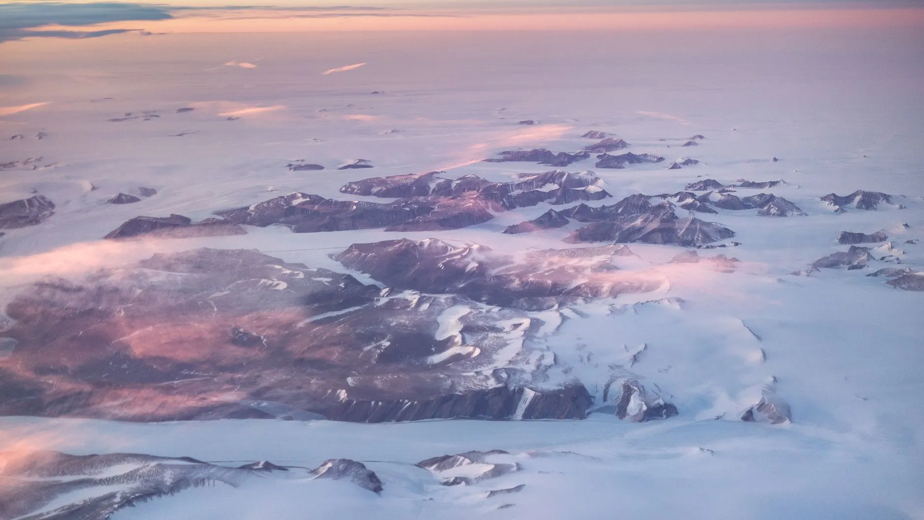 Kangerlussuaq, Greenland — Stunning aerial shot of Greenland's winter landscape with fjords, ice, and mountains at sunset.