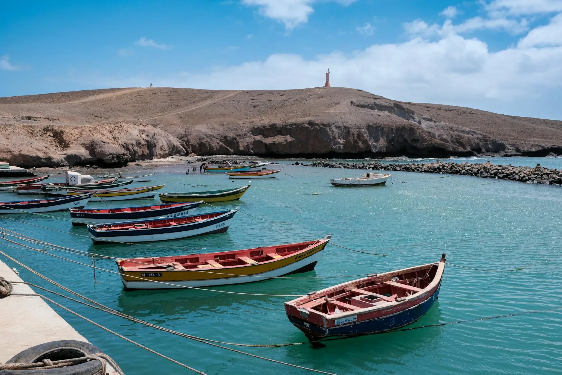 Sal, Cape Verde — Lively scene of colorful fishing boats anchored in the serene waters of Pedra Lume, Sal, Cabo Verde.