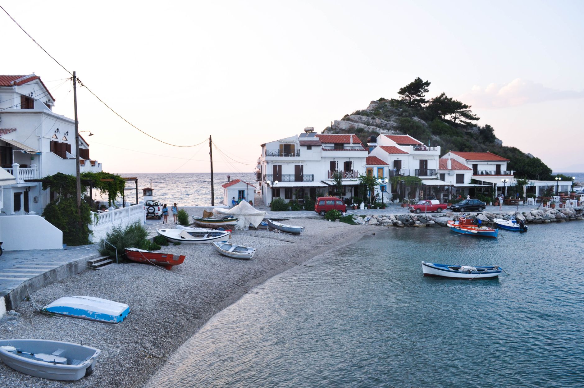 Samos, Greece — Charming coastal village in Samos, Greece, at sunset with boats and traditional architecture.