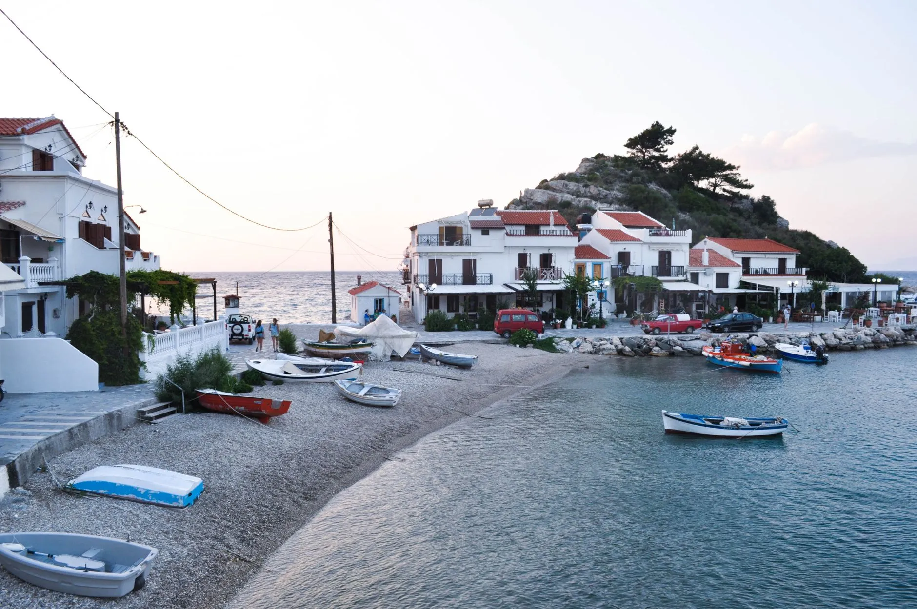 Samos, Greece — Charming coastal village in Samos, Greece, at sunset with boats and traditional architecture.