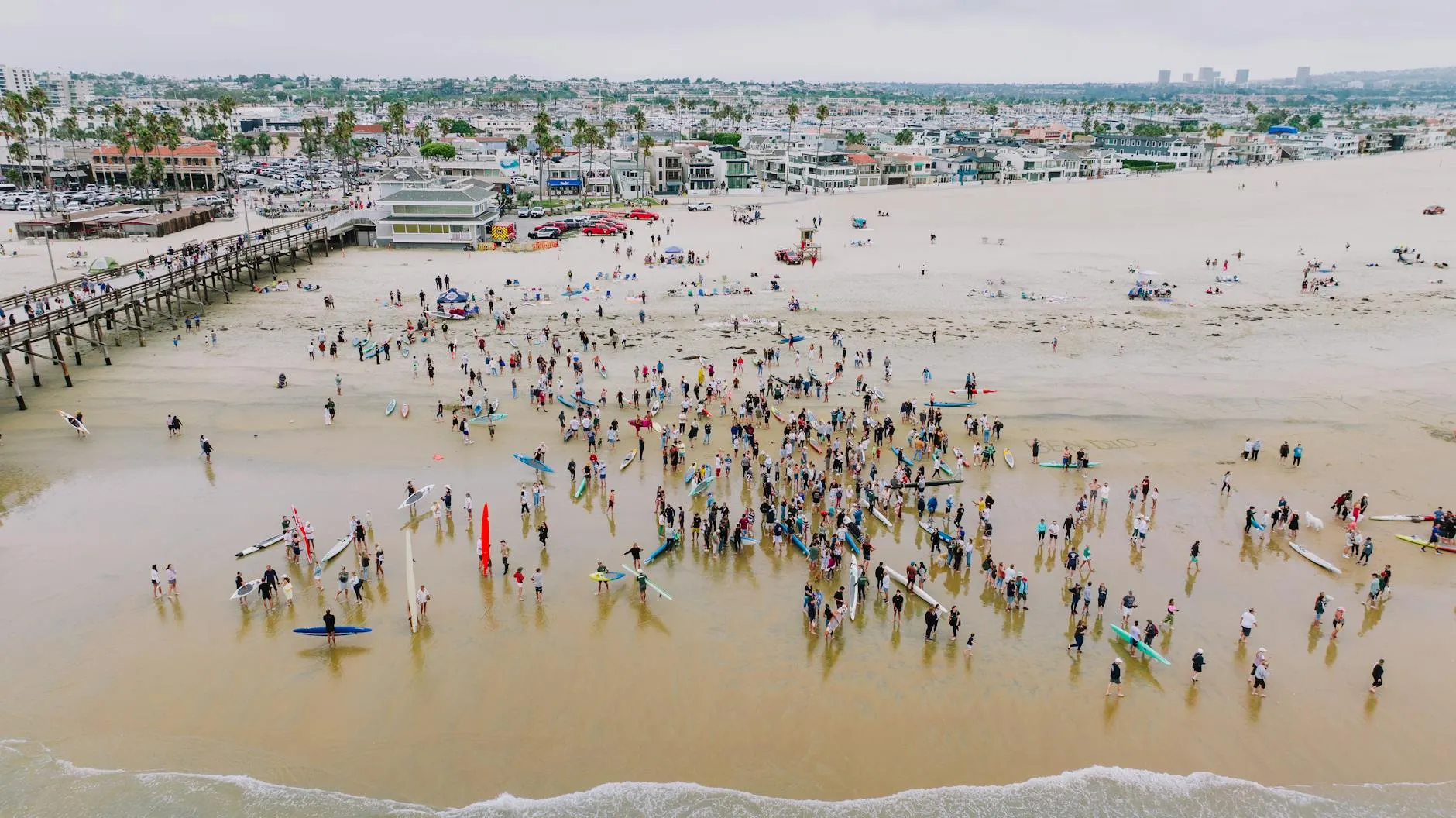Orange County, USA — A vibrant aerial shot of surfers gathered at Newport Beach, California, showcasing community and coastal lifestyle.