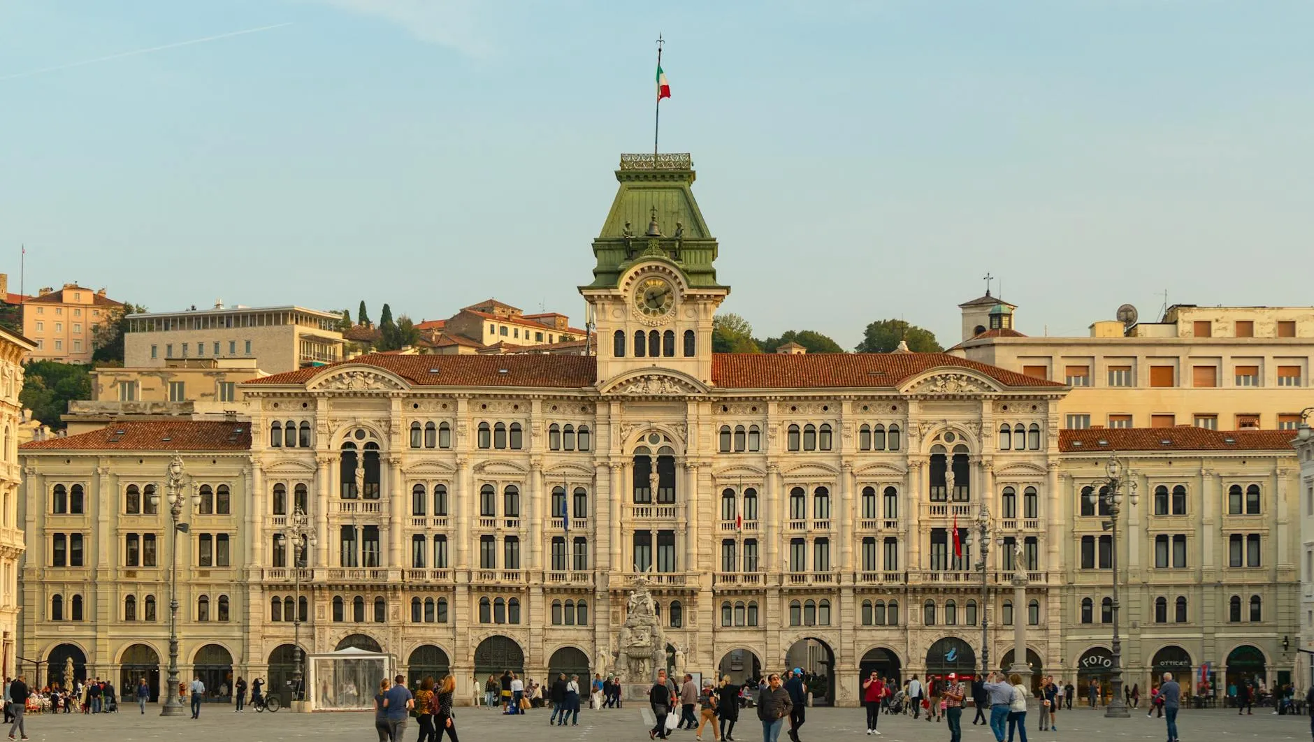 Trieste, Italy — View of the historic Trieste Town Hall in Piazza Unità d'Italia, bustling with people.