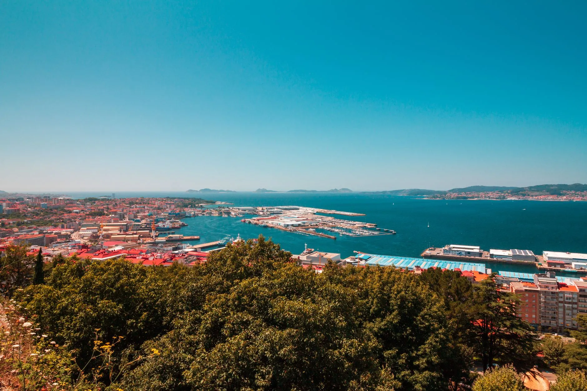 Vigo, Galicia — Aerial panoramic view of Vigo port, Spain, showcasing vibrant cityscape and blue sea under a clear sky.