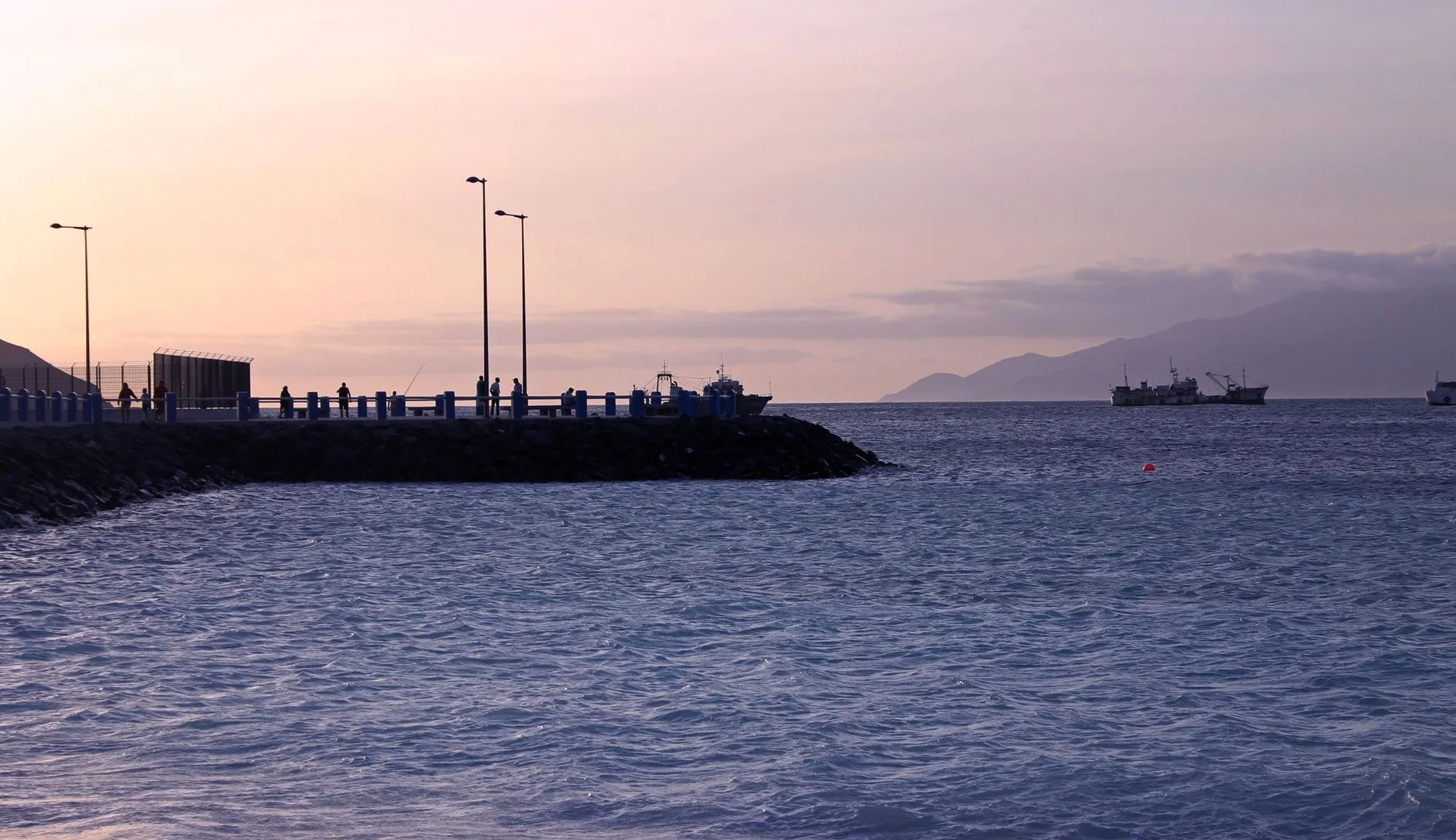 Mindelo, Cape Verde — Serene morning view of Mindelo's harbor in São Vicente, Cabo Verde, with ships and seawall silhouetted against the dawn sky.