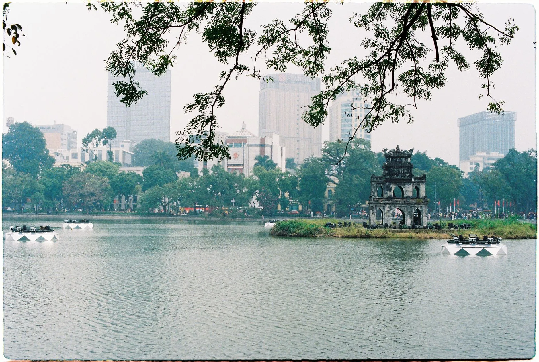 Hanoi's Turtle Tower on Hoan Kiem Lake with the city skyline behind