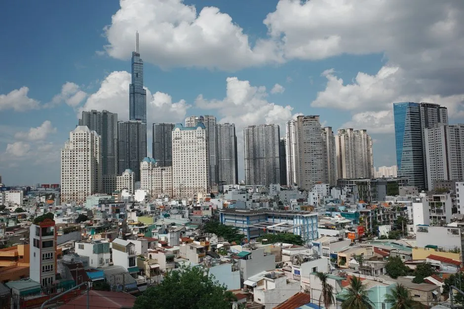 Ho Chi Minh City, Vietnam — the Landmark 81 tower rising above the city's dense low-rise neighbourhoods under a bright cloudy sky