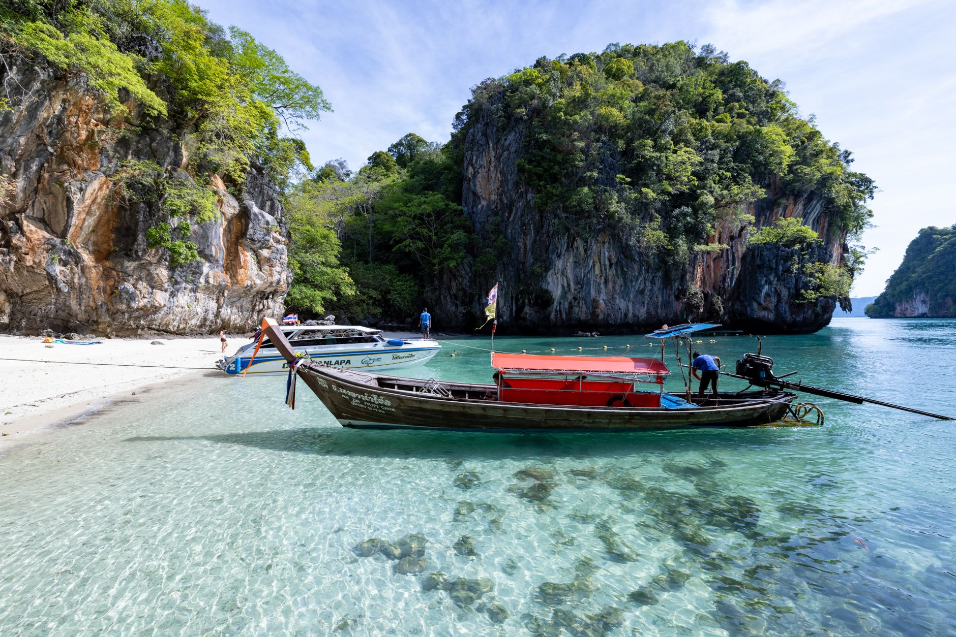 A longtail boat on a limestone-fringed beach in southern Thailand