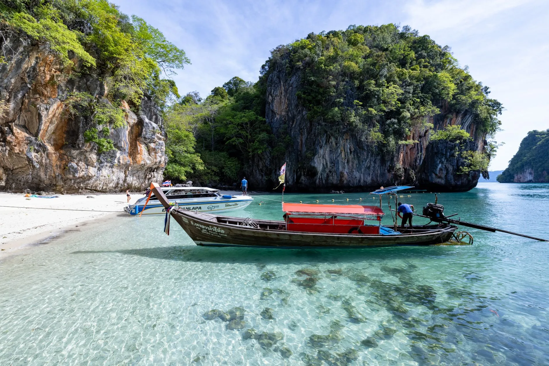 A longtail boat on a limestone-fringed beach in southern Thailand