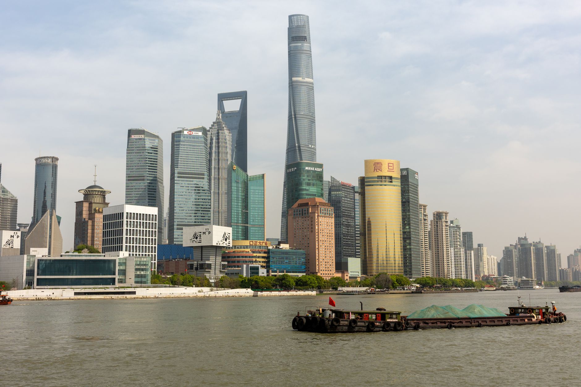 Dynamic view of Lujiazui's iconic skyscrapers along Huangpu River in Shanghai, China.
