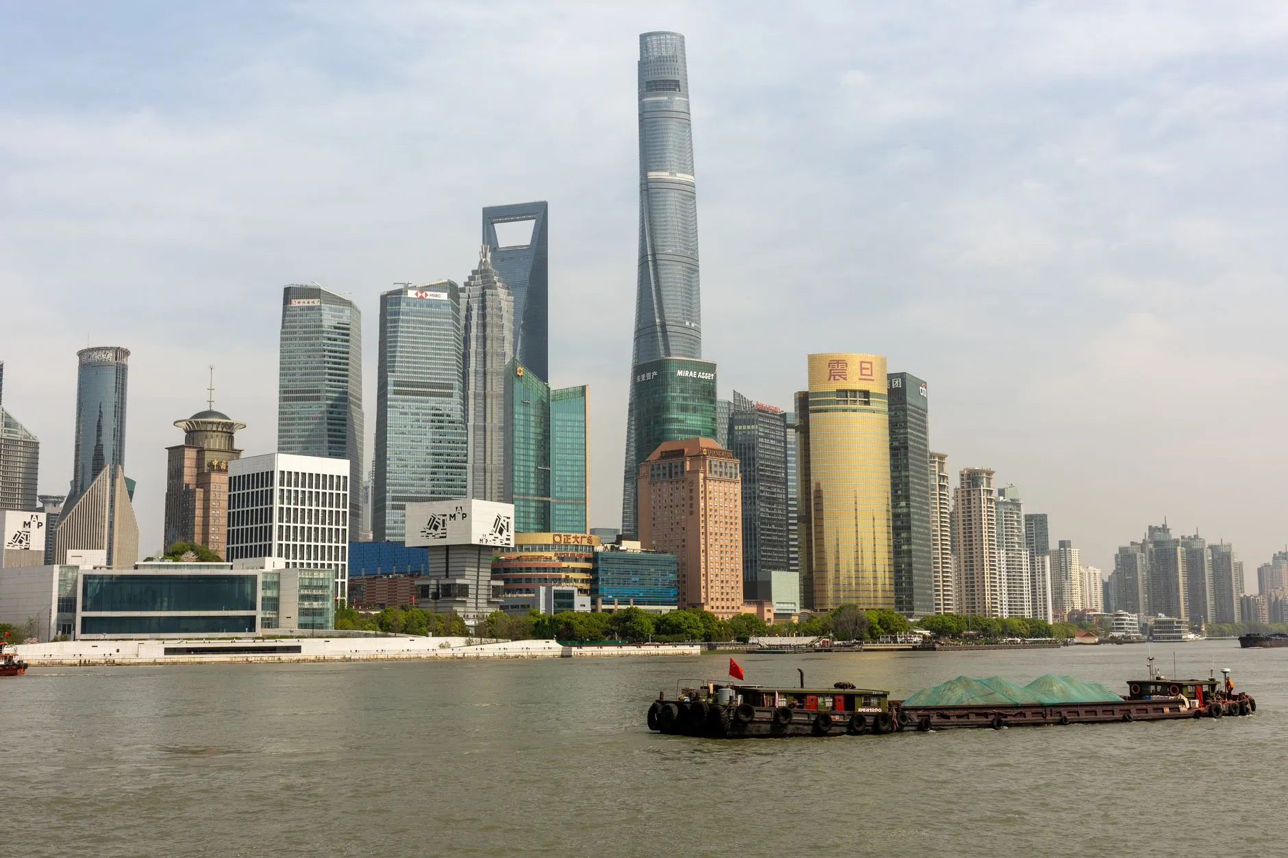 Dynamic view of Lujiazui's iconic skyscrapers along Huangpu River in Shanghai, China.