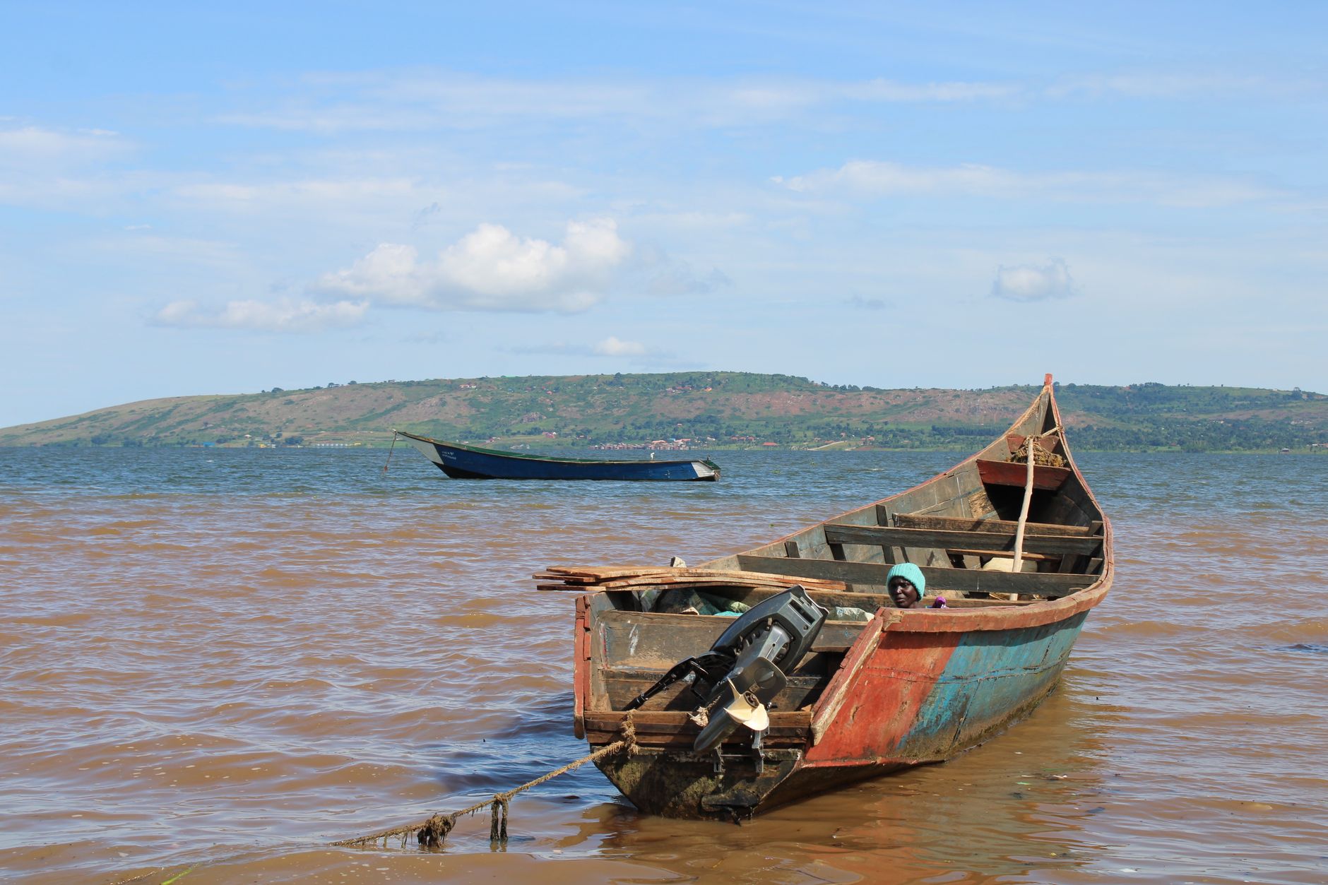 Rustic fishing boat moored on Lake Victoria in Jinja, Uganda, under a clear sky.