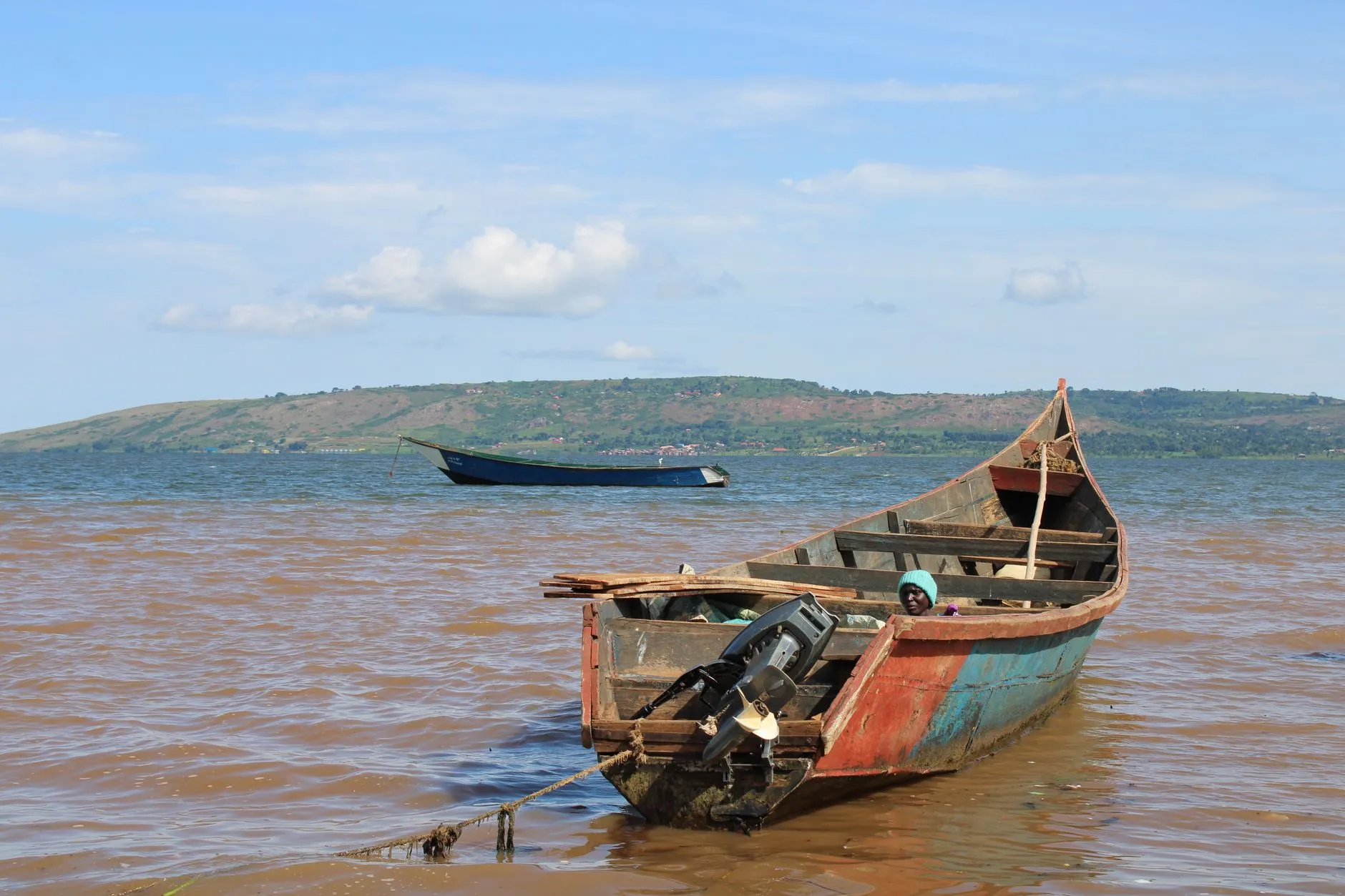 Rustic fishing boat moored on Lake Victoria in Jinja, Uganda, under a clear sky.