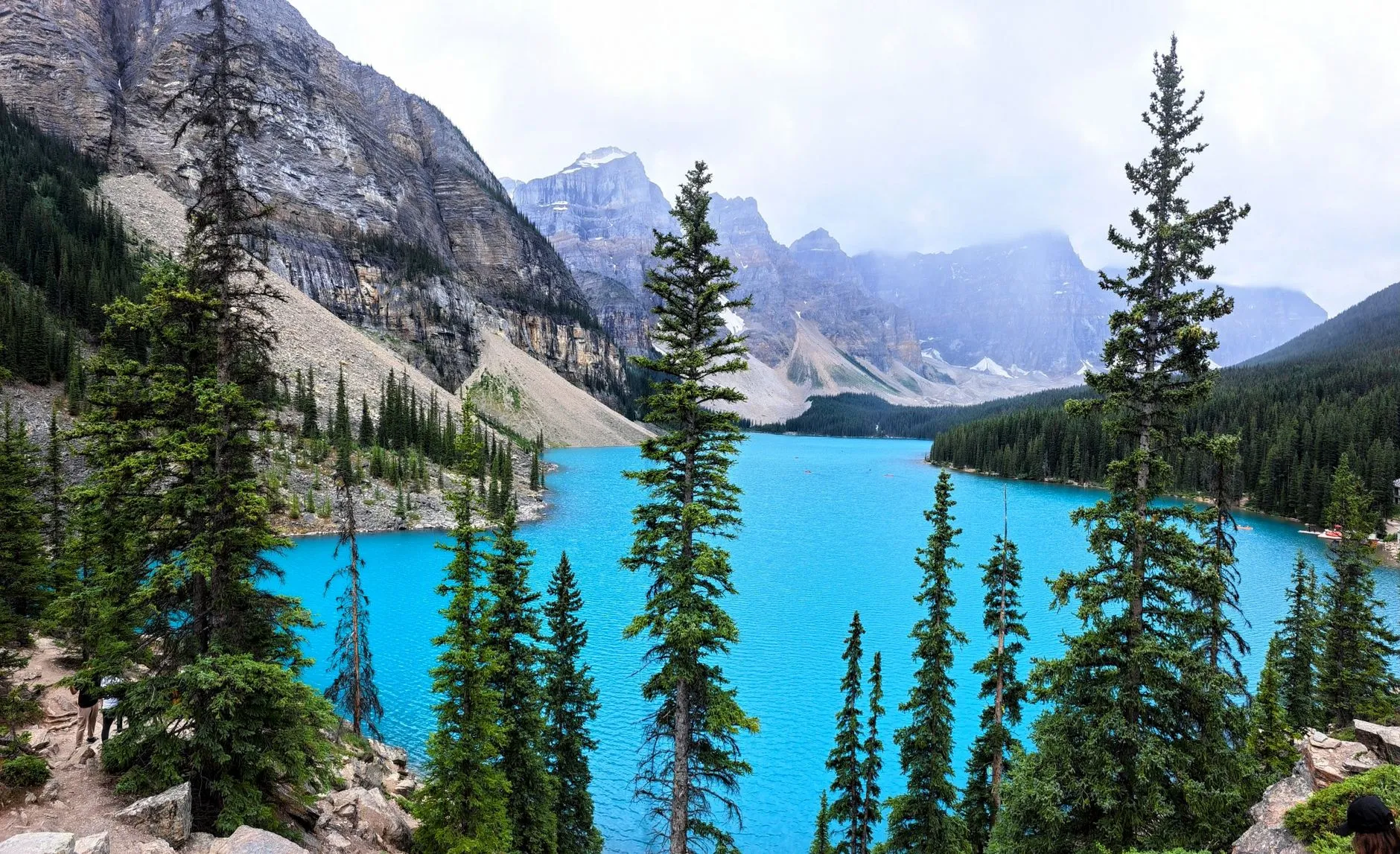 Turquoise glacial lake ringed by spruce forest and rocky peaks in the Canadian Rockies west of Calgary, Alberta