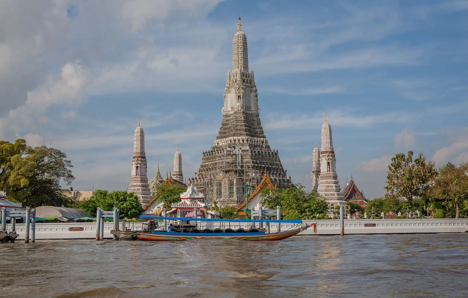 Wat Arun temple along the Chao Phraya River in Bangkok, Thailand, on a clear day.