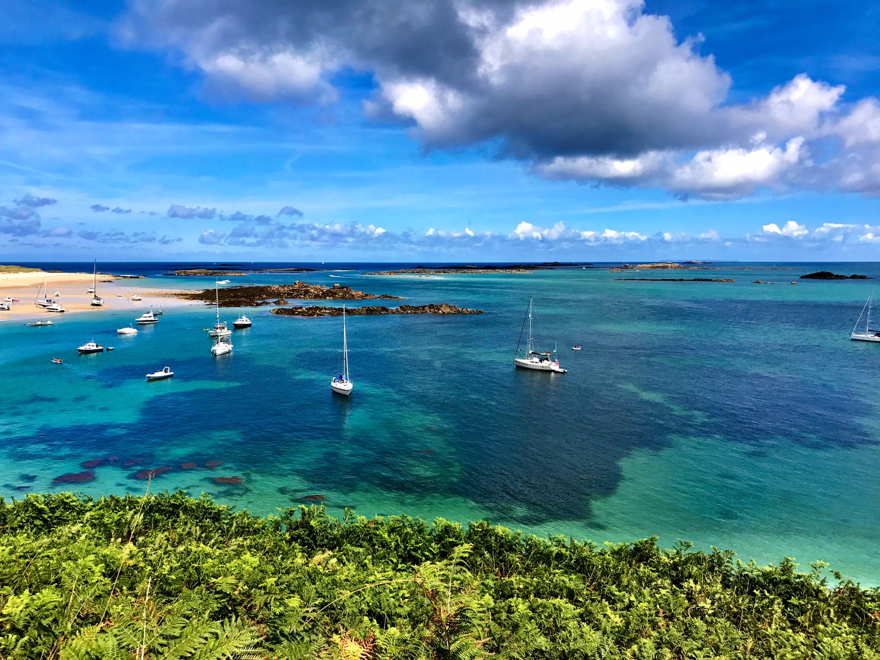 Guernsey, Channel Islands — Beautiful seascape of Herm, Guernsey featuring sailboats on clear blue water with a vibrant sky.
